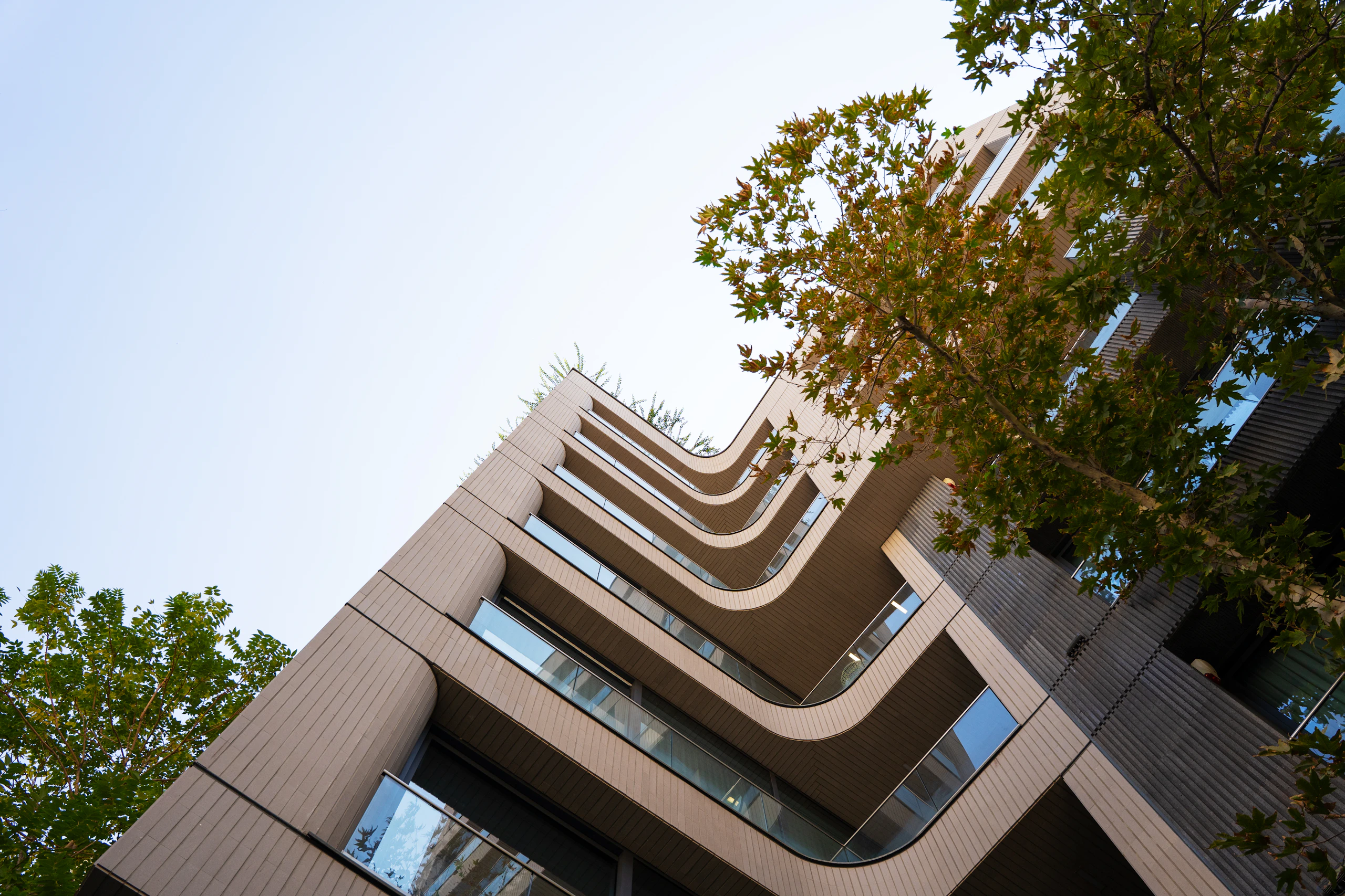 Building with curved balconies and trees