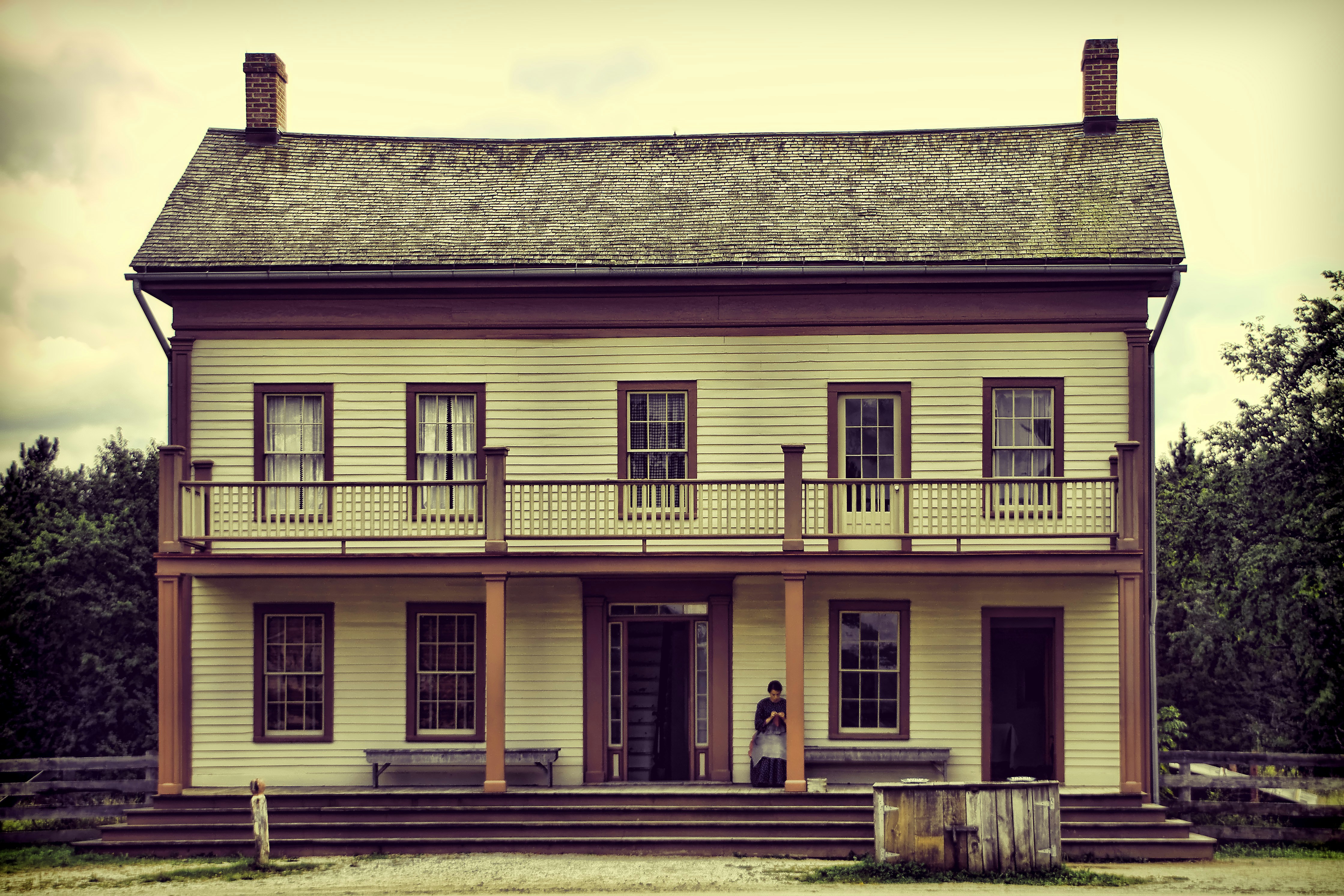A light yellow two-story house with a balcony