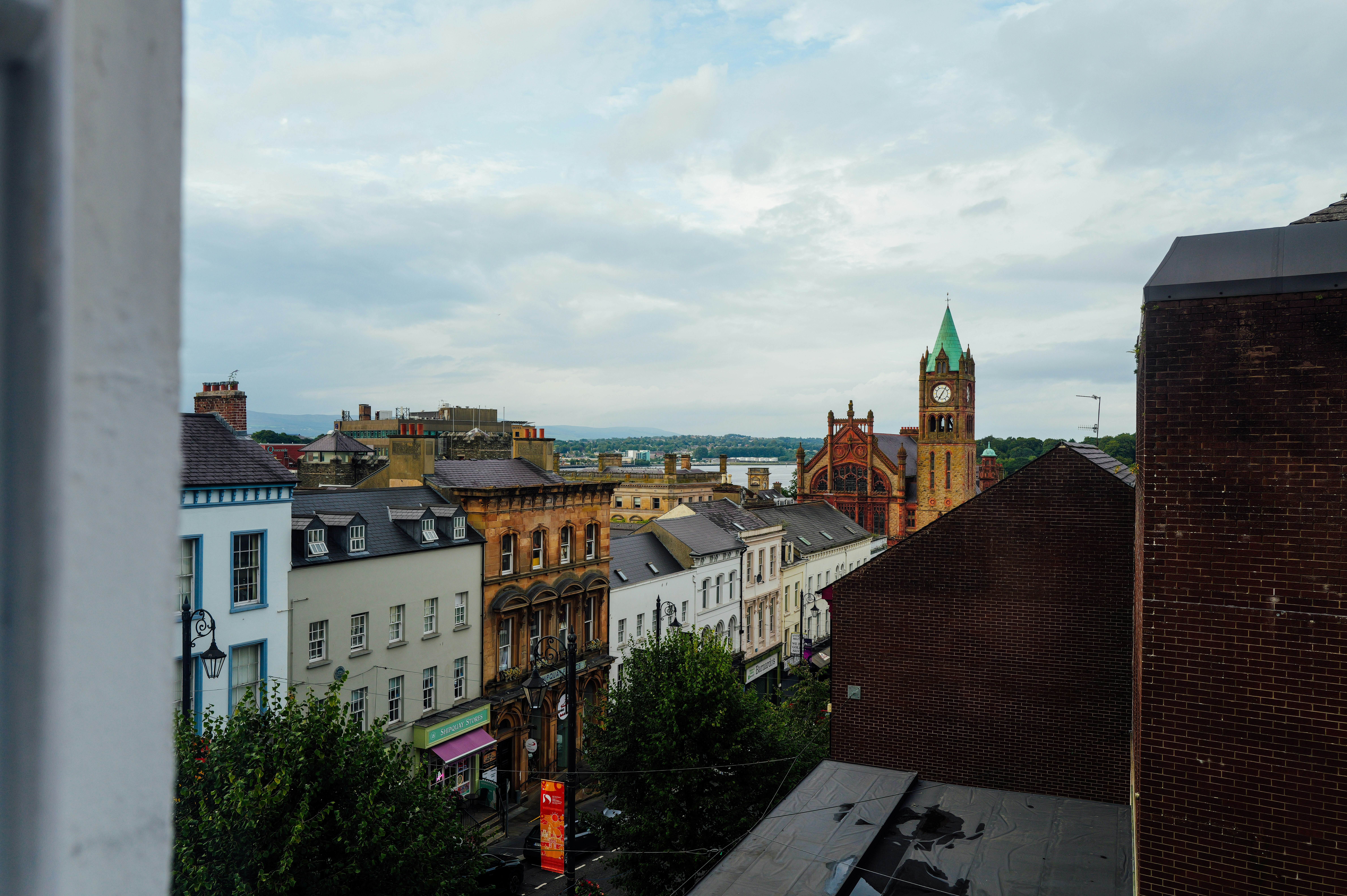 View of town with clock tower and distant water.