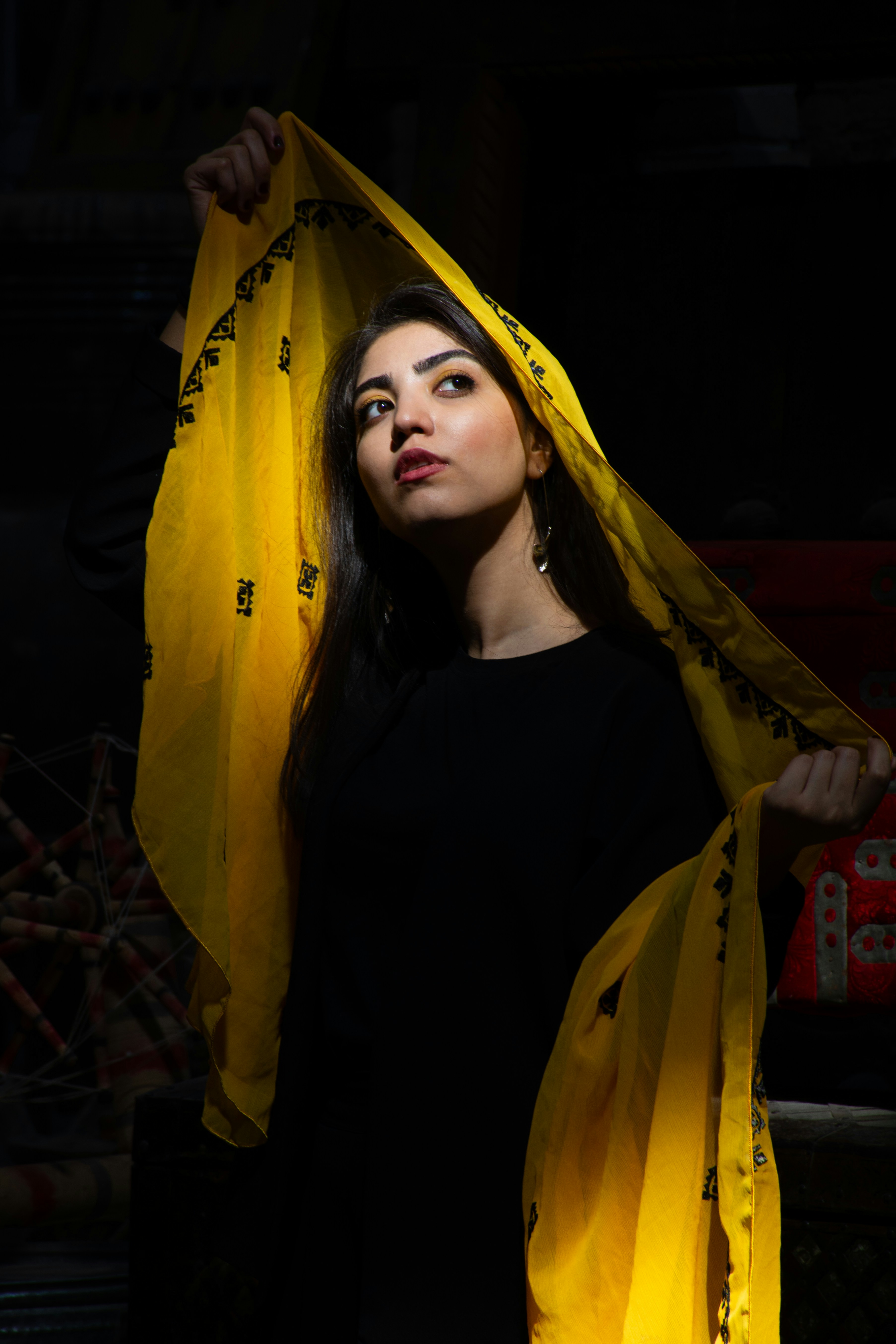 Woman with yellow fabric over her head