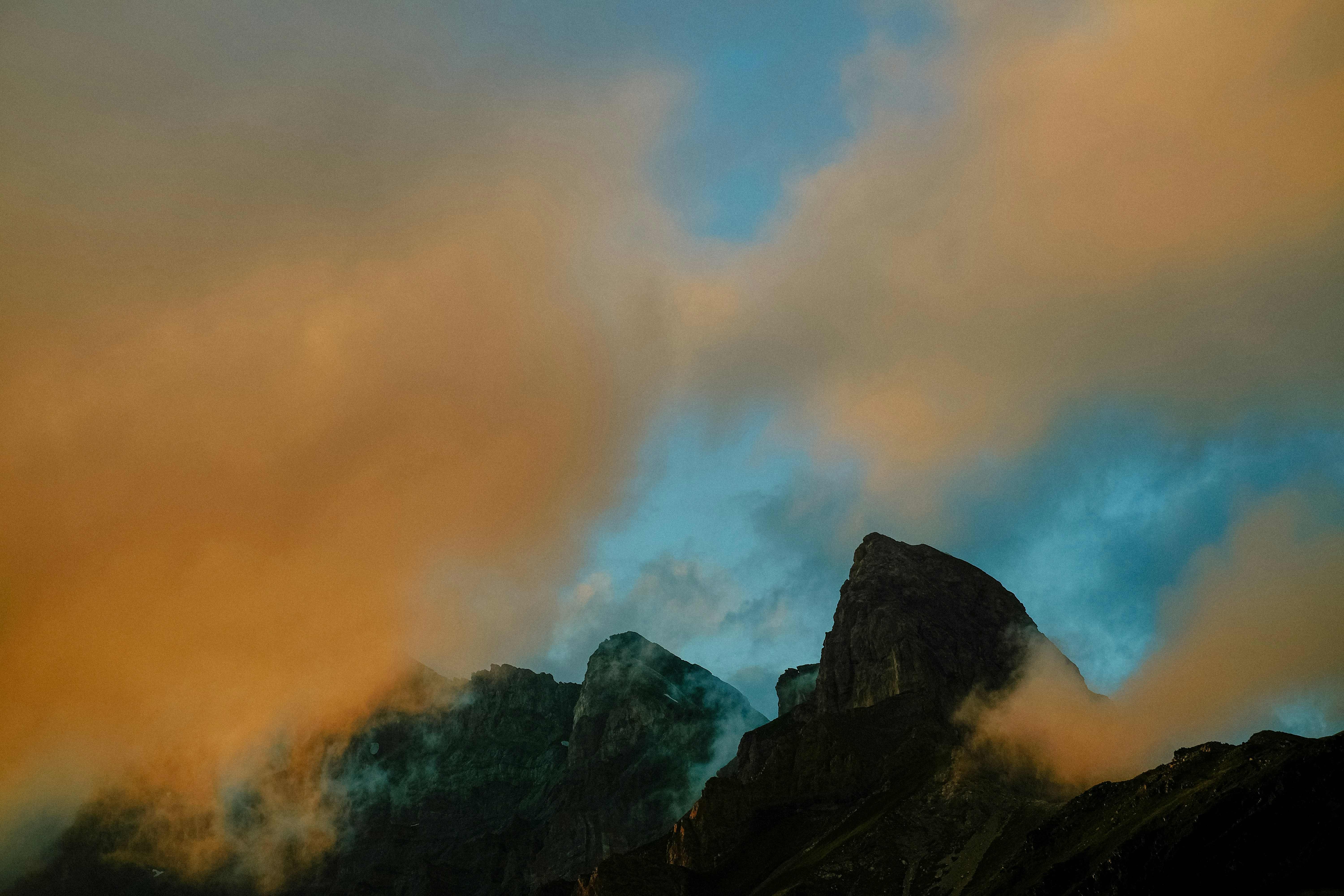 Mountain peaks shrouded in dramatic sunset clouds