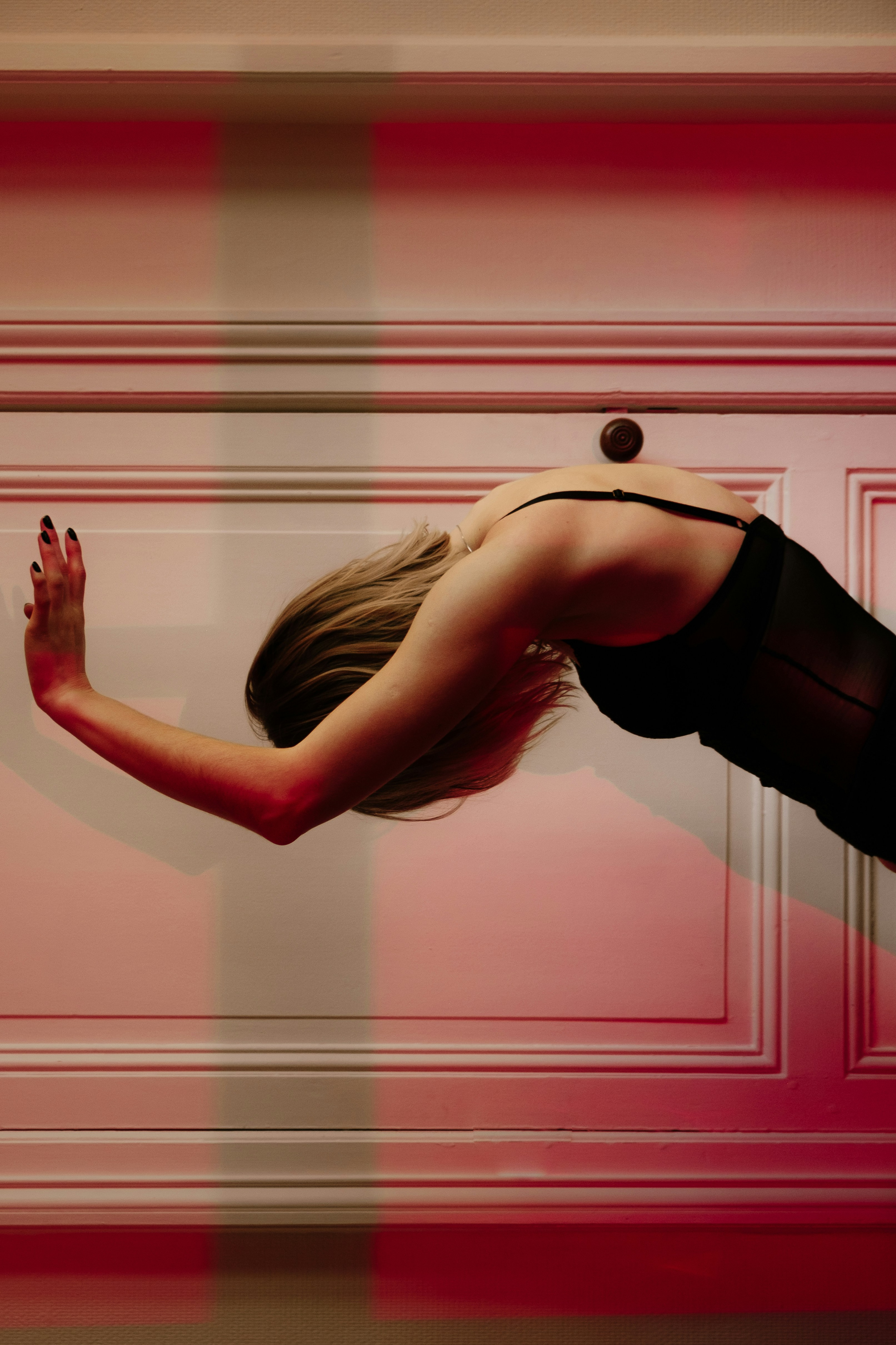 Woman in lingerie leaning against a door