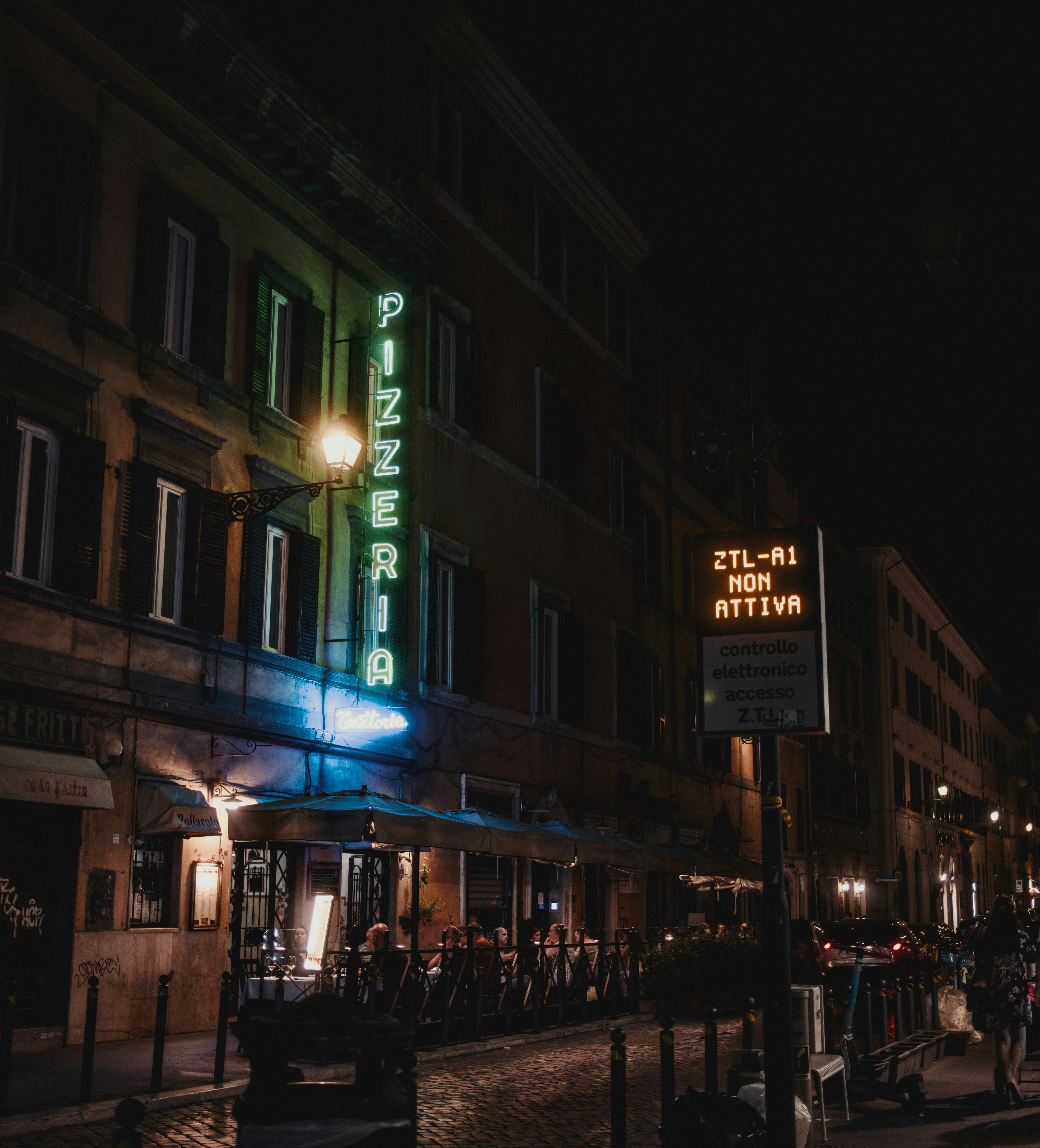 Pizzeria sign glowing at night on a street
