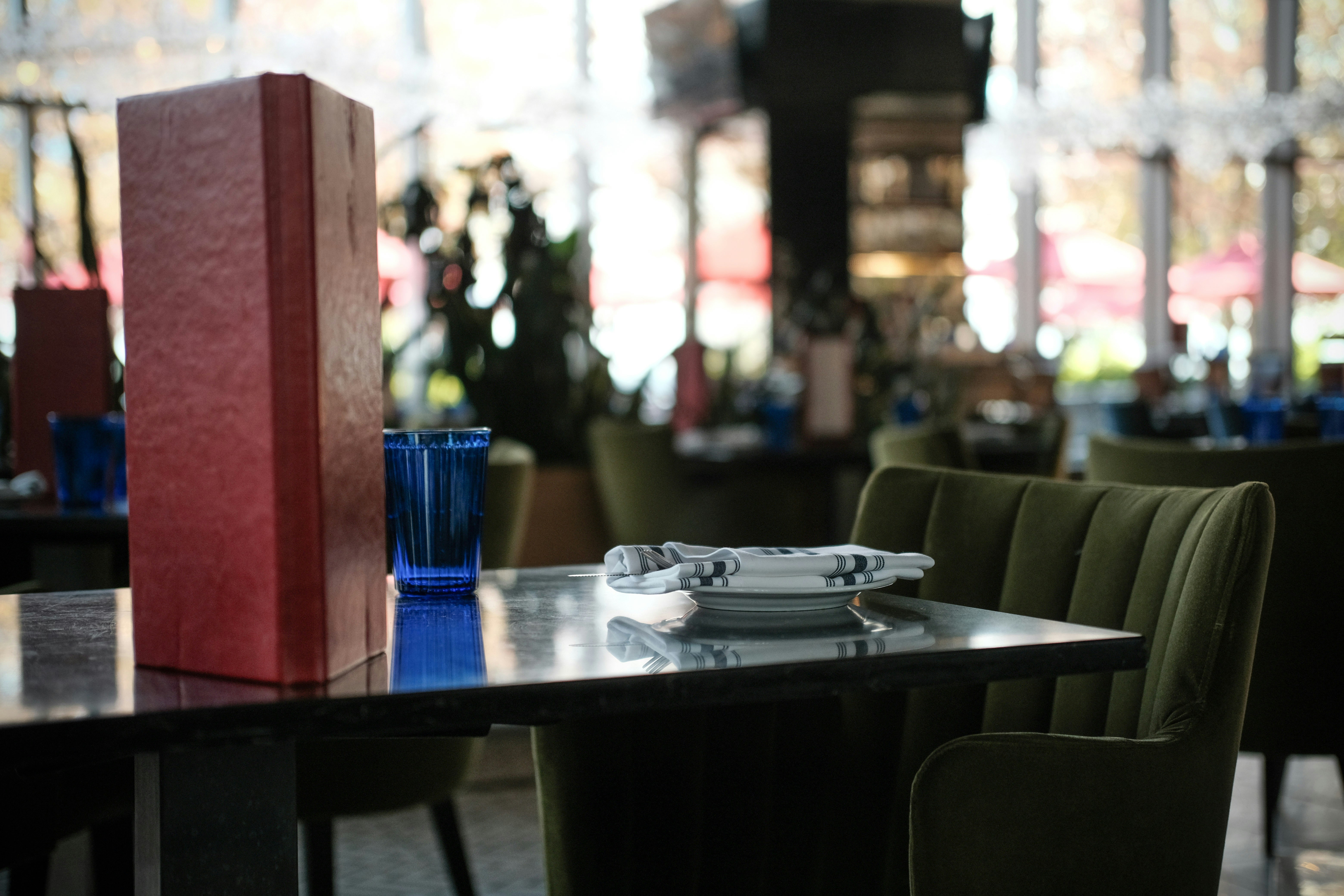Table setting in a restaurant with red menu holder