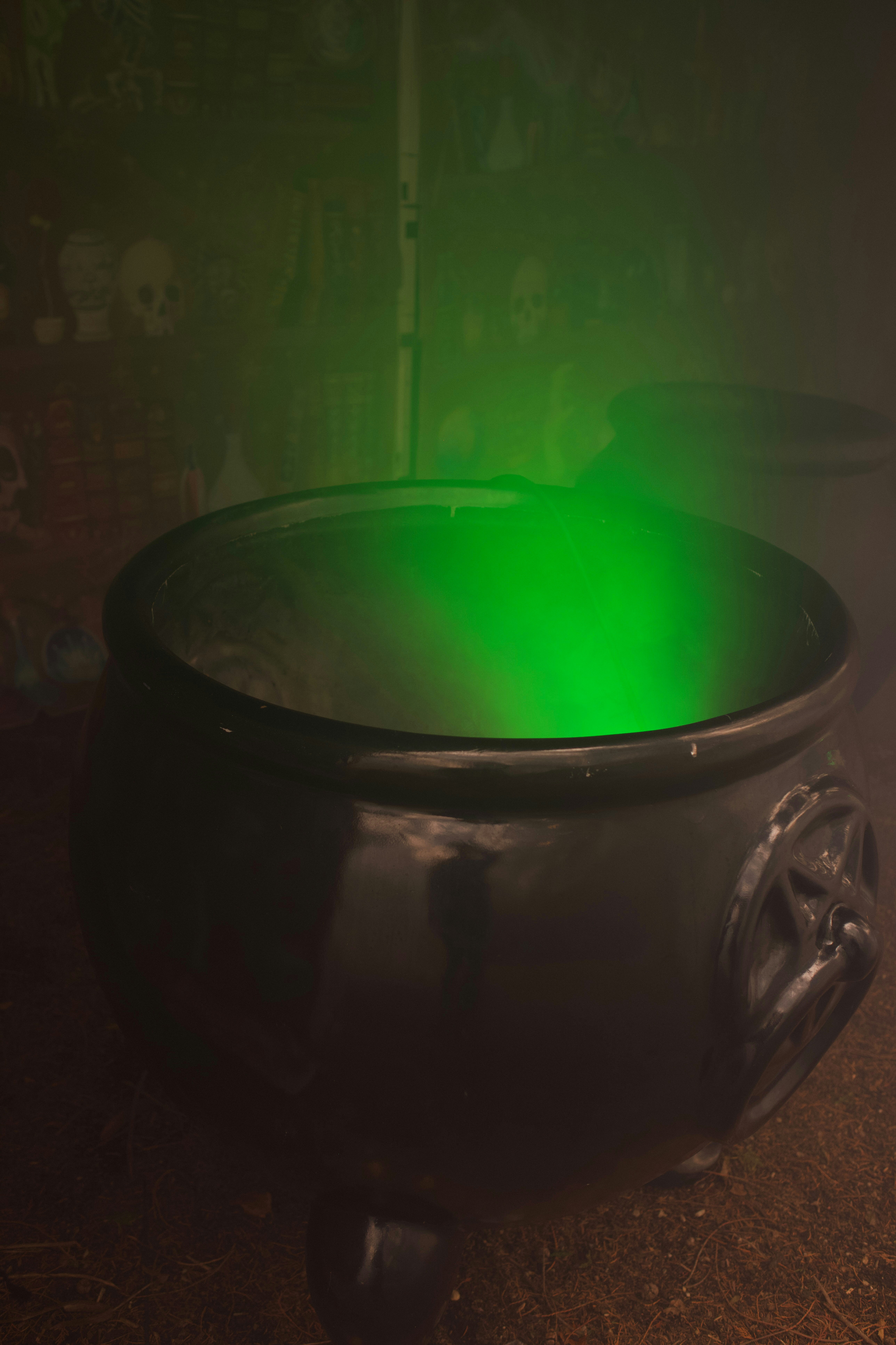 A black cauldron with glowing green mist inside