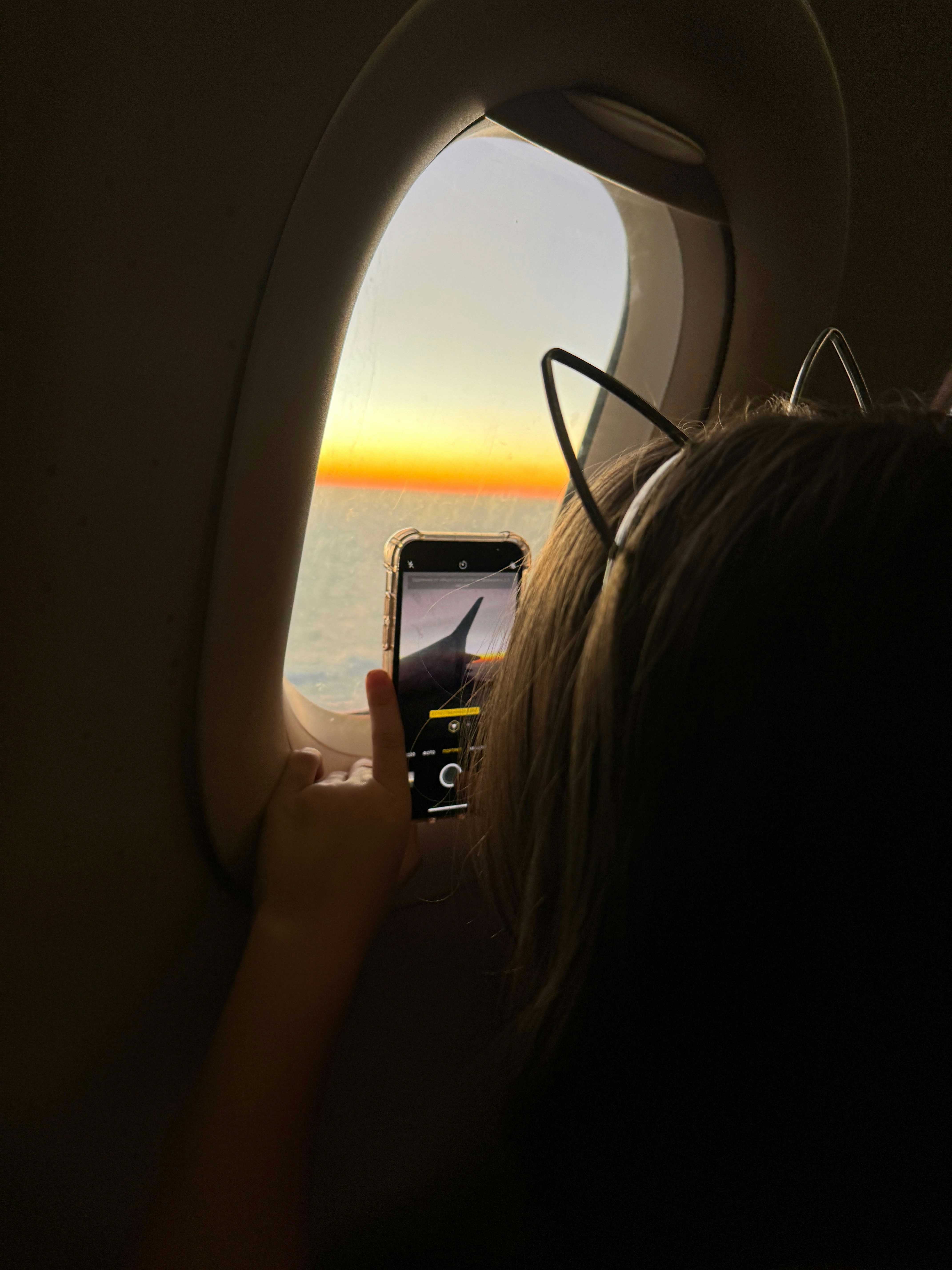 Child takes picture of sunset from airplane window