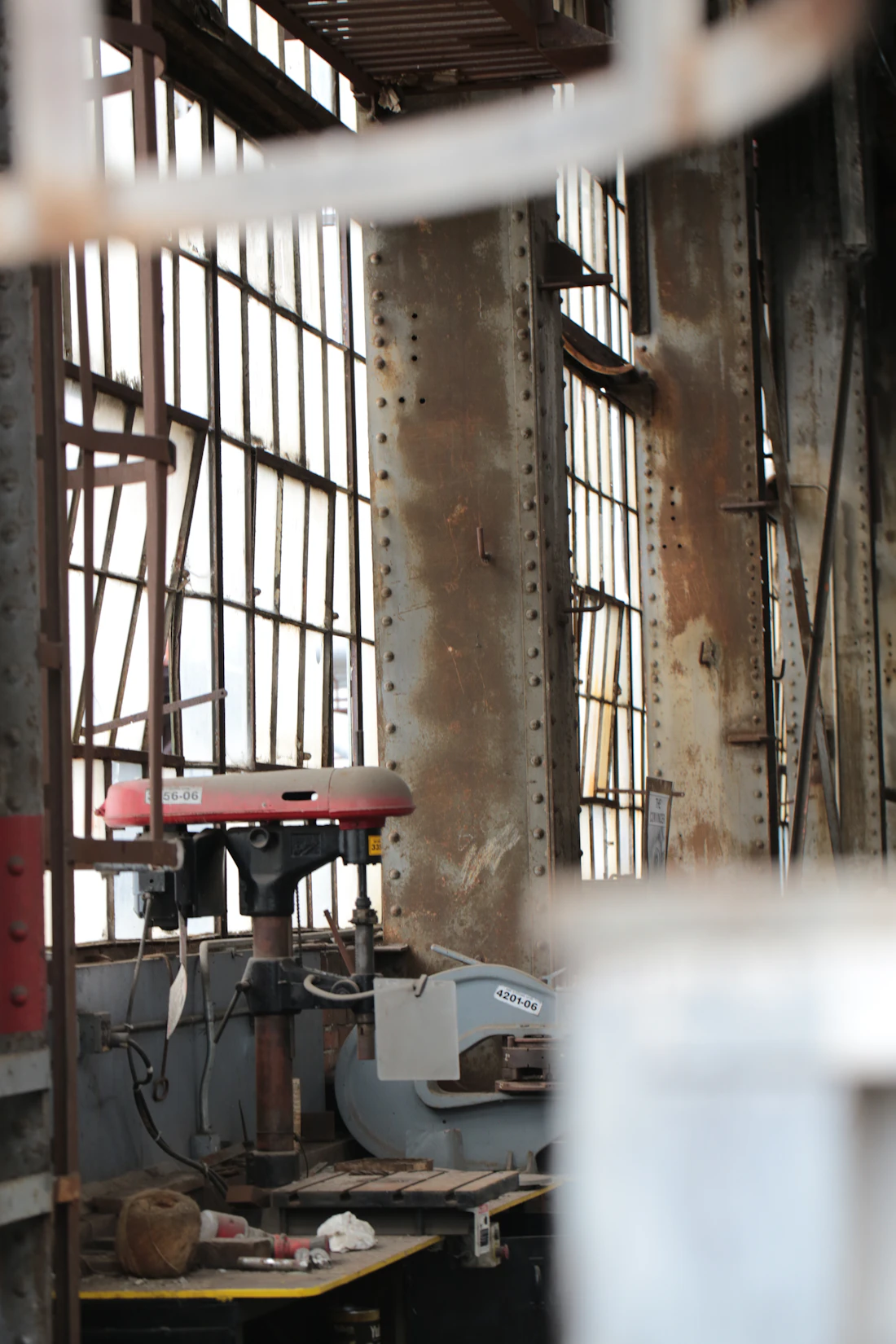 Industrial metalworking workshop with machinery, steel stock and large windows