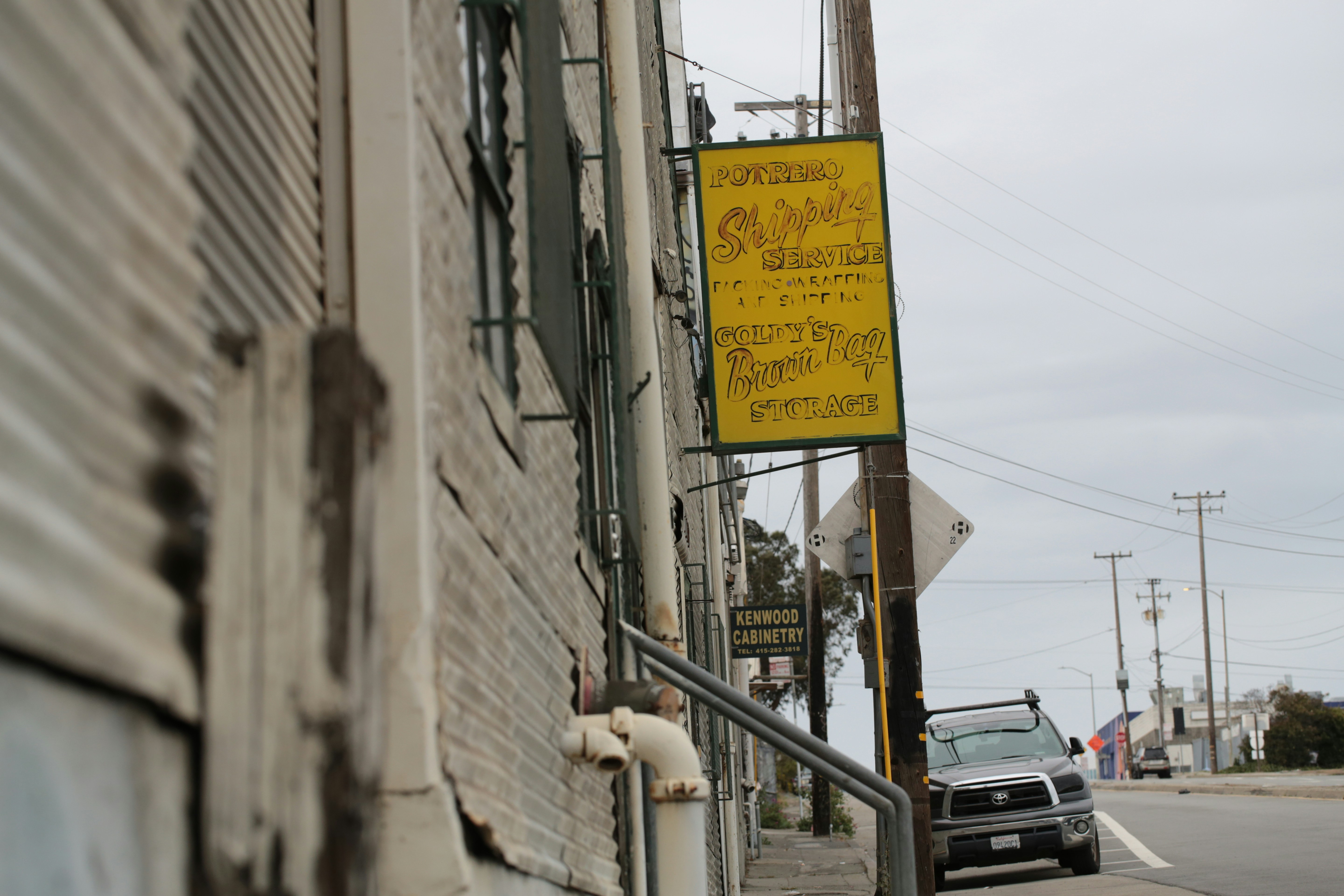 Yellow sign on corrugated building wall