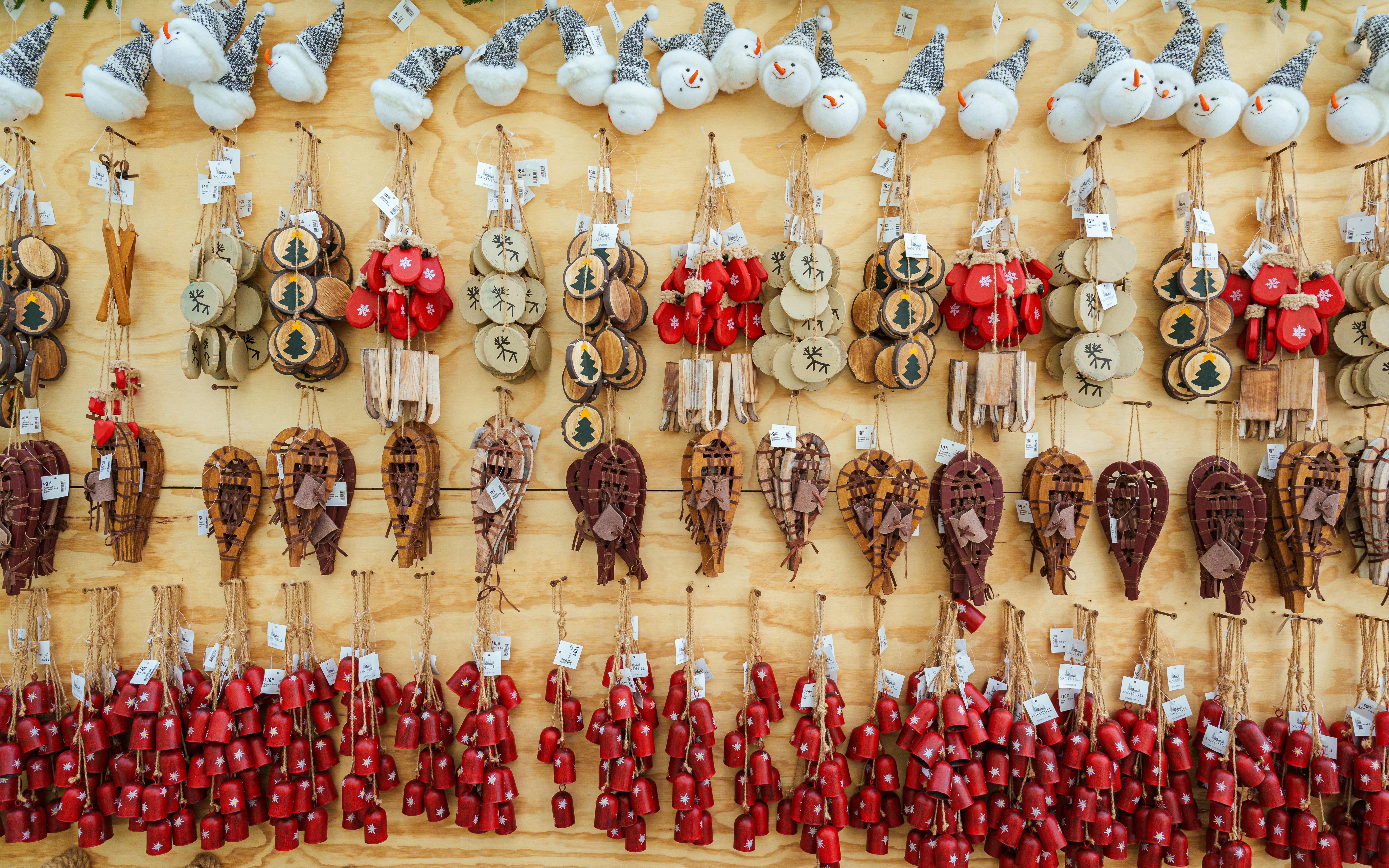 Various handmade ornaments hanging on a wooden wall.