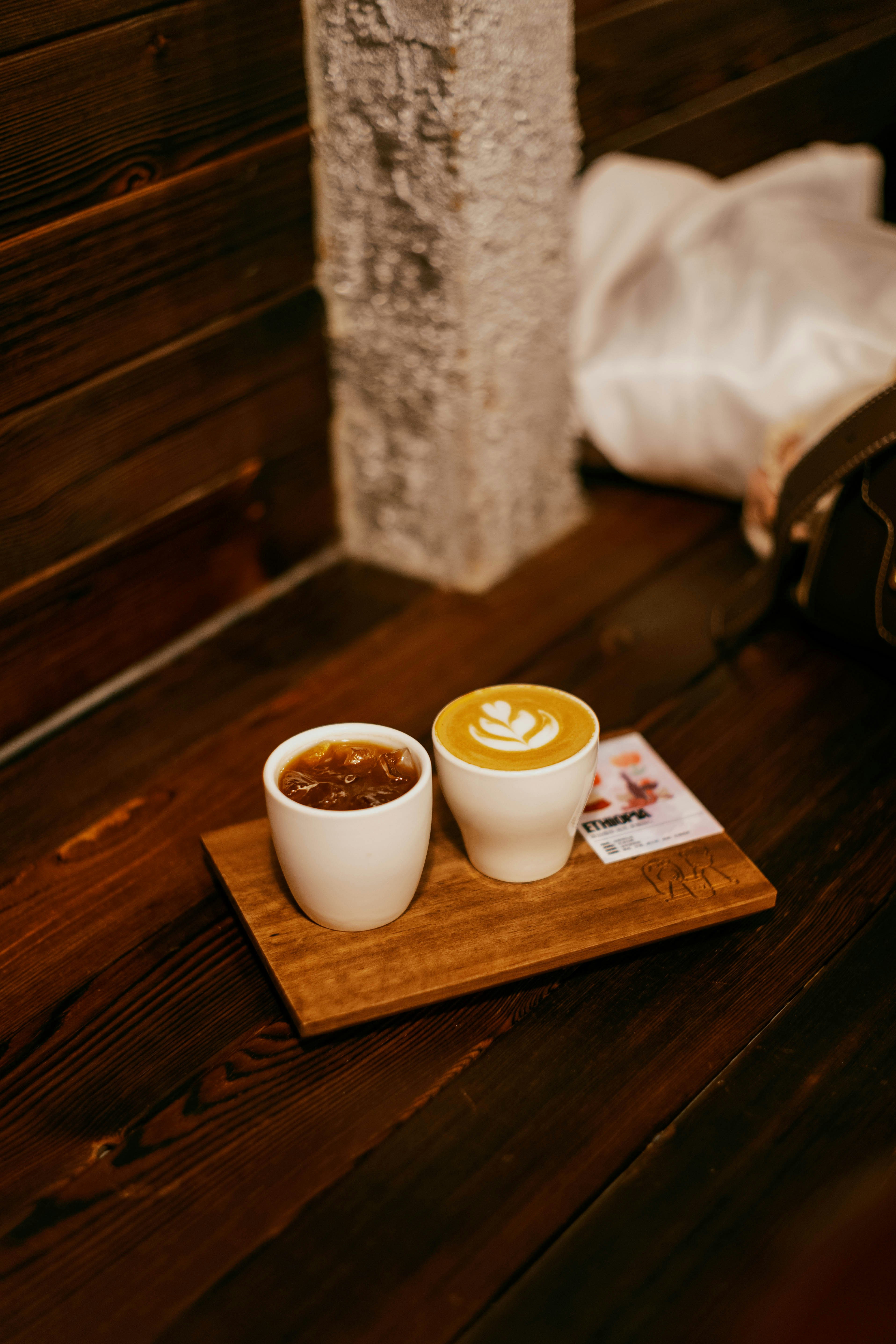 Dos bebidas de café en una bandeja de madera