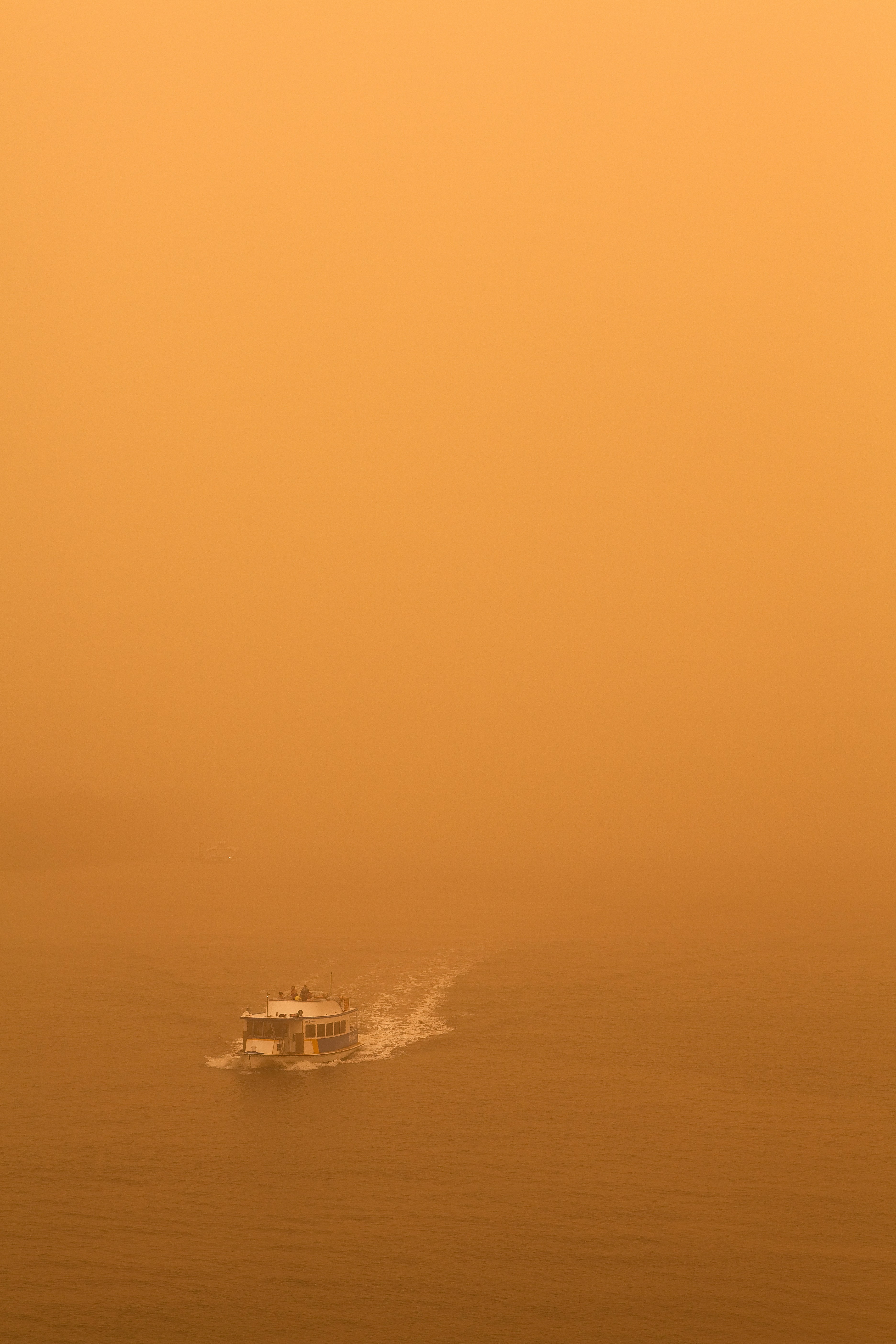 A boat travels through hazy orange water