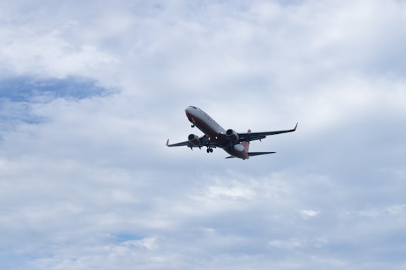 Airplane ascending into a cloudy sky