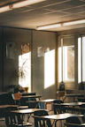 Sunlight streams into an empty classroom with desks