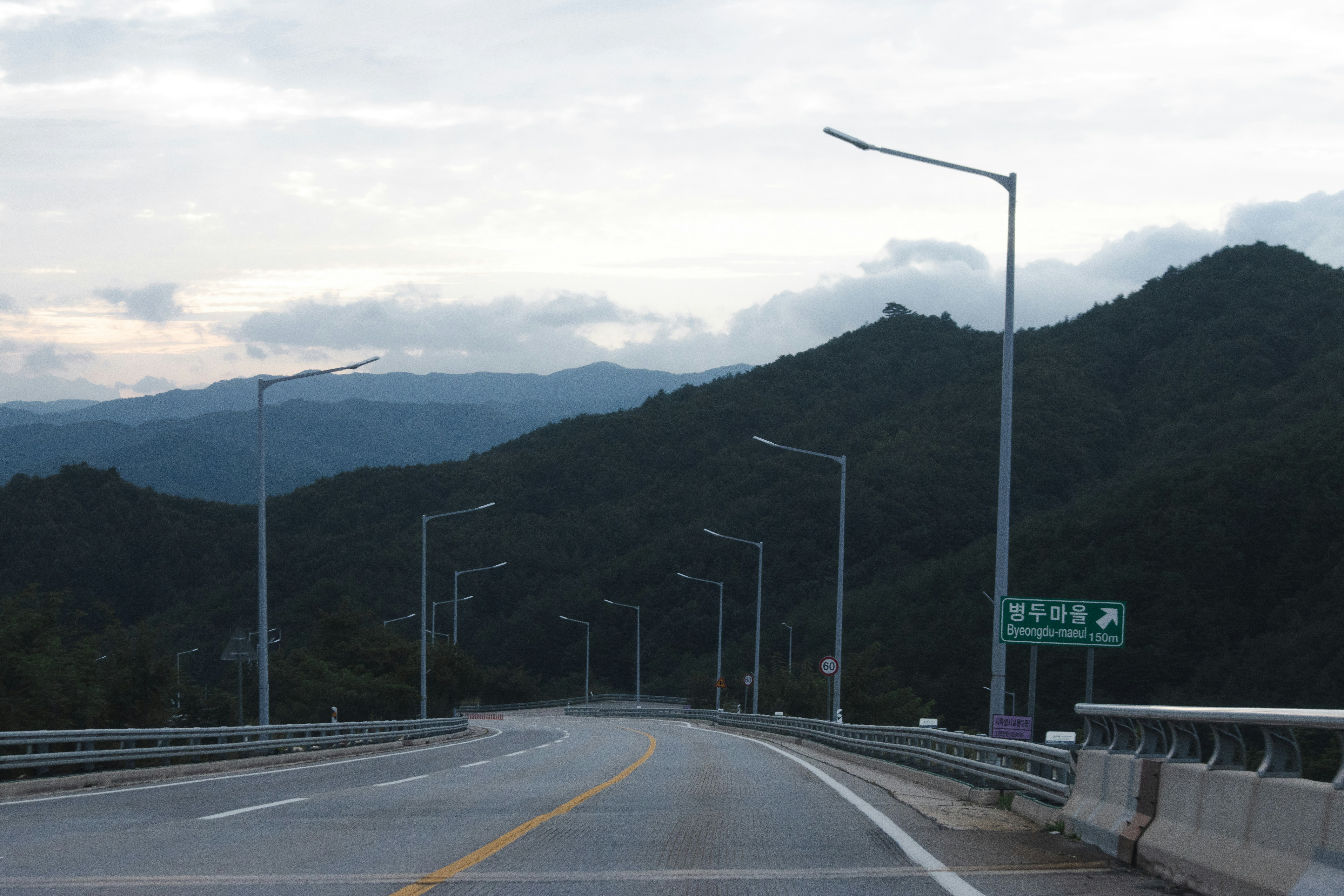 La carretera vacía pasa a través de montañas boscosas