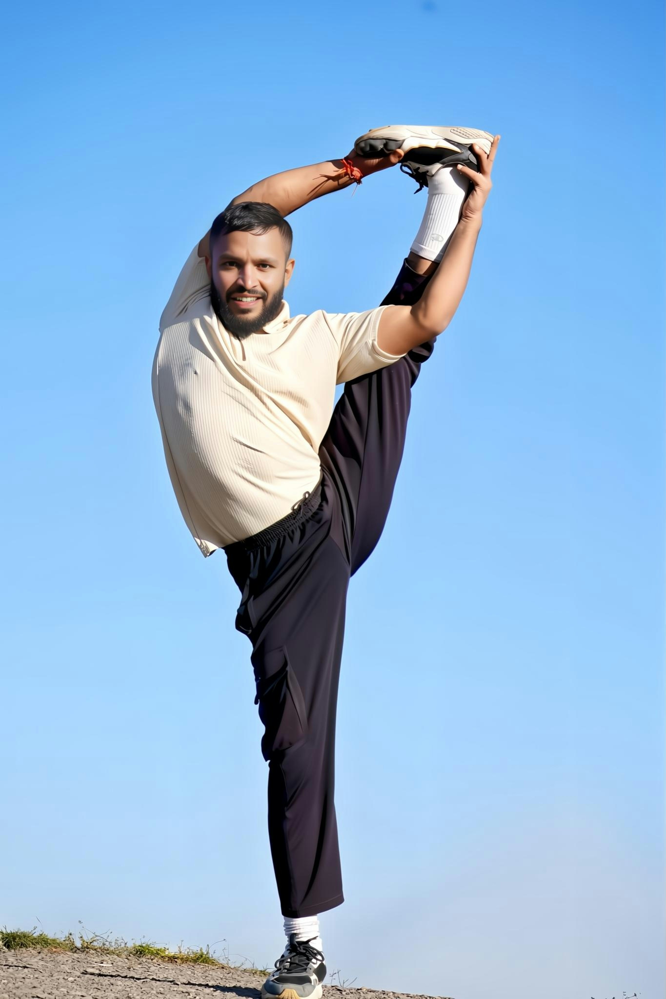 Man in athletic wear performs a standing split pose.