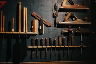 Various woodworking tools neatly arranged on a dark wall.