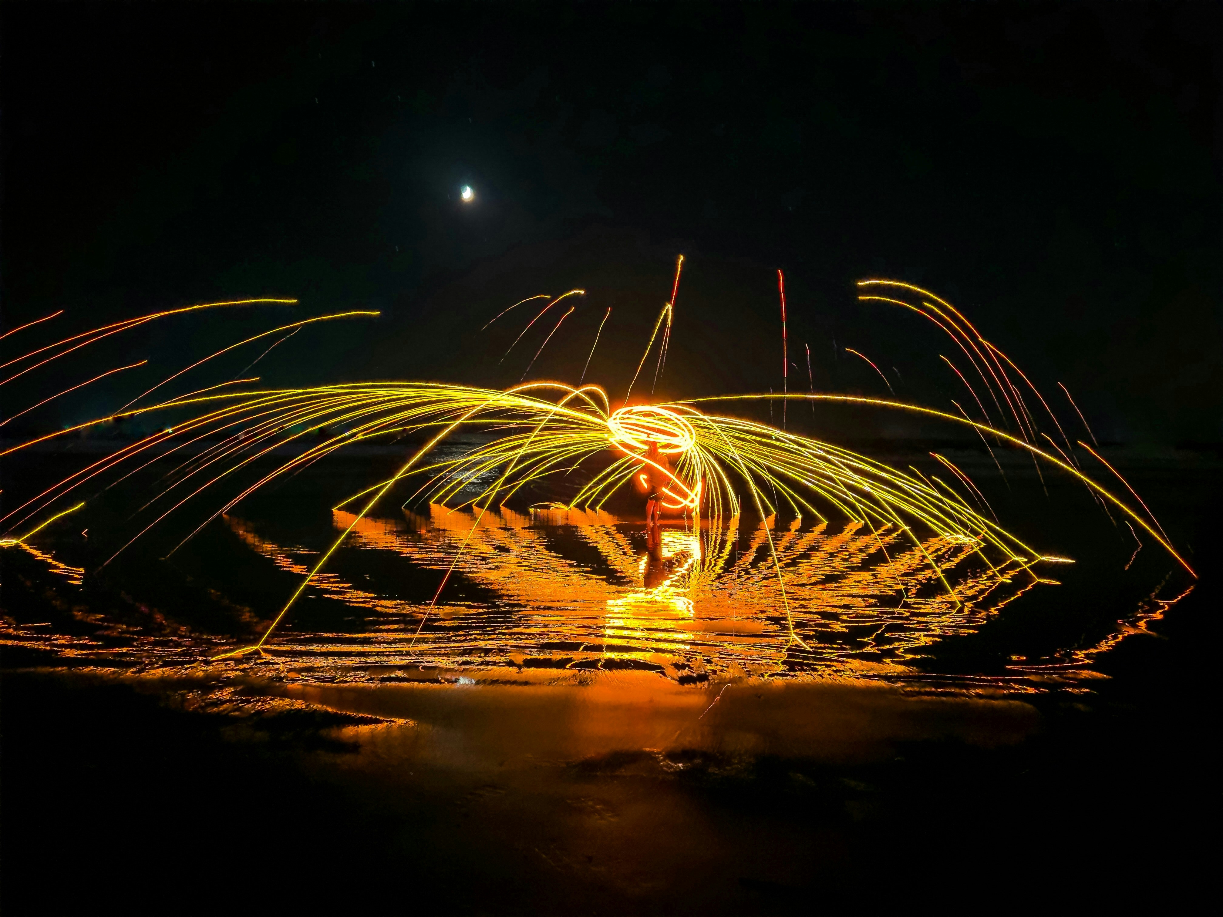 Person spinning burning steel wool at night