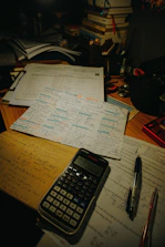 Desk with calculator, pens, and study papers