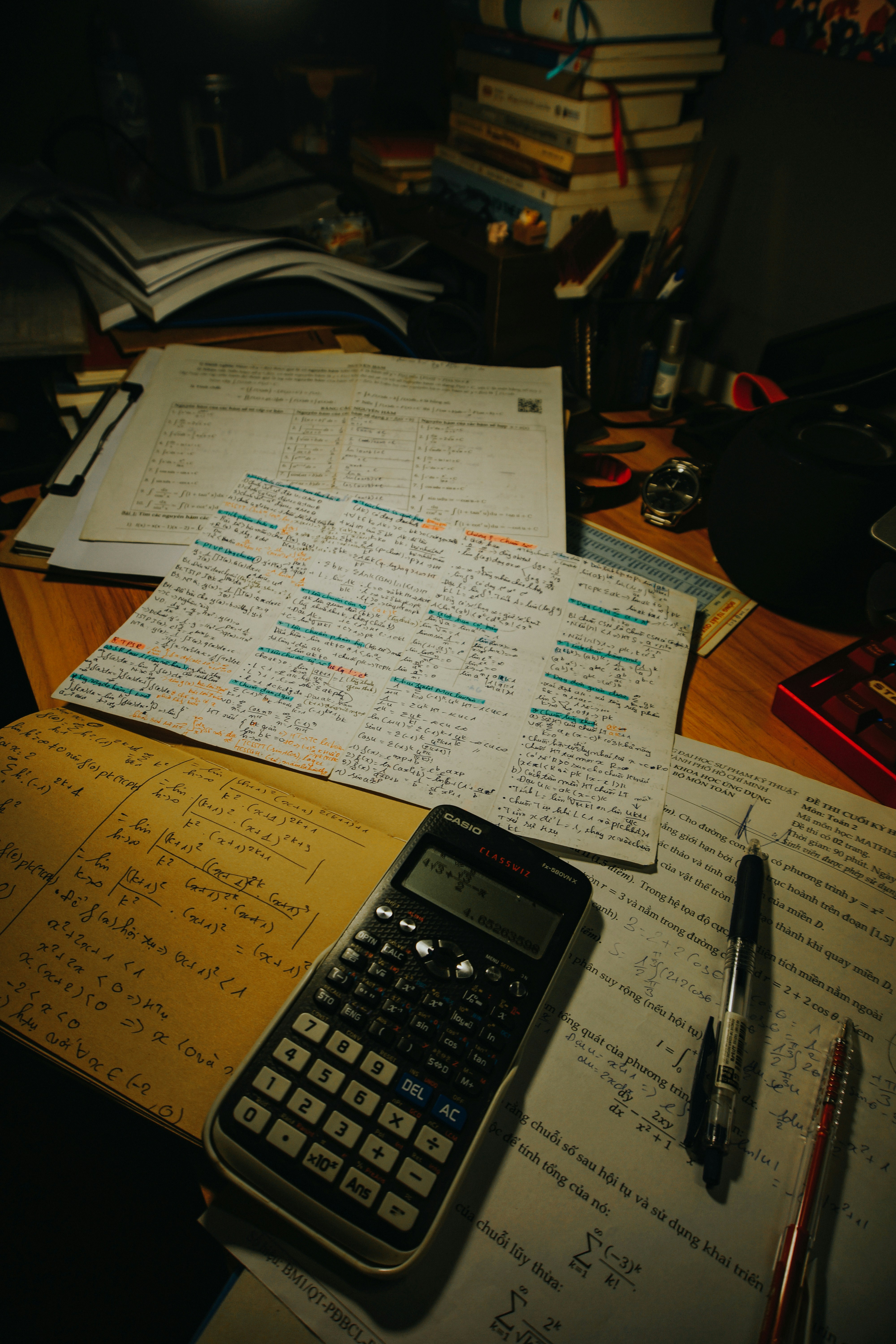 Desk with calculator, pens, and study papers