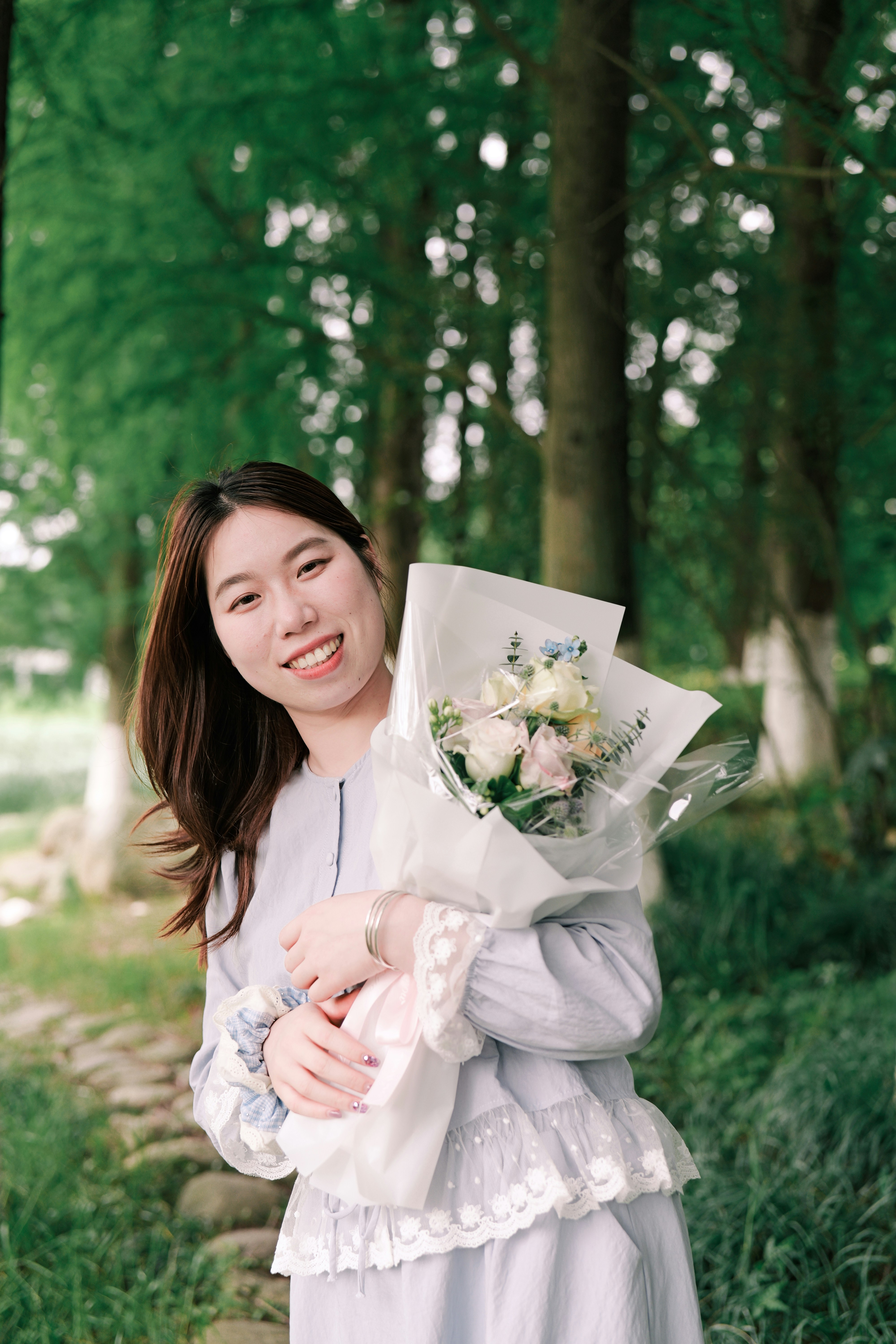 A smiling young woman holding a bouquet of flowers.