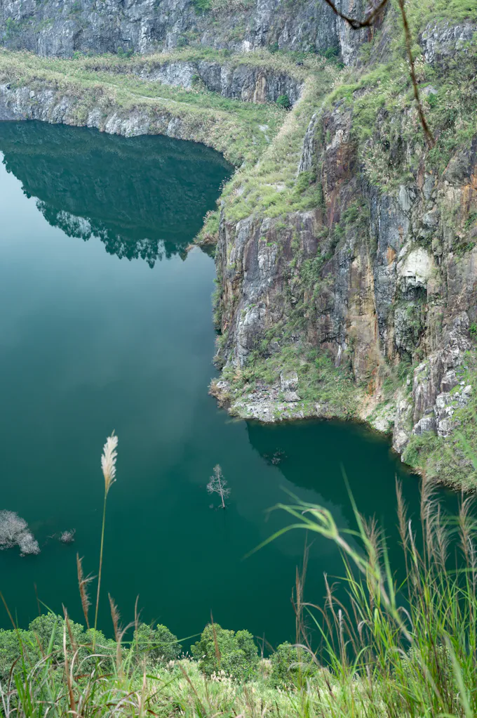 Deep green water filling a quarry with rocky cliffs, similar to the flooded quarry known locally as the Blue Hole in Ganister, PA