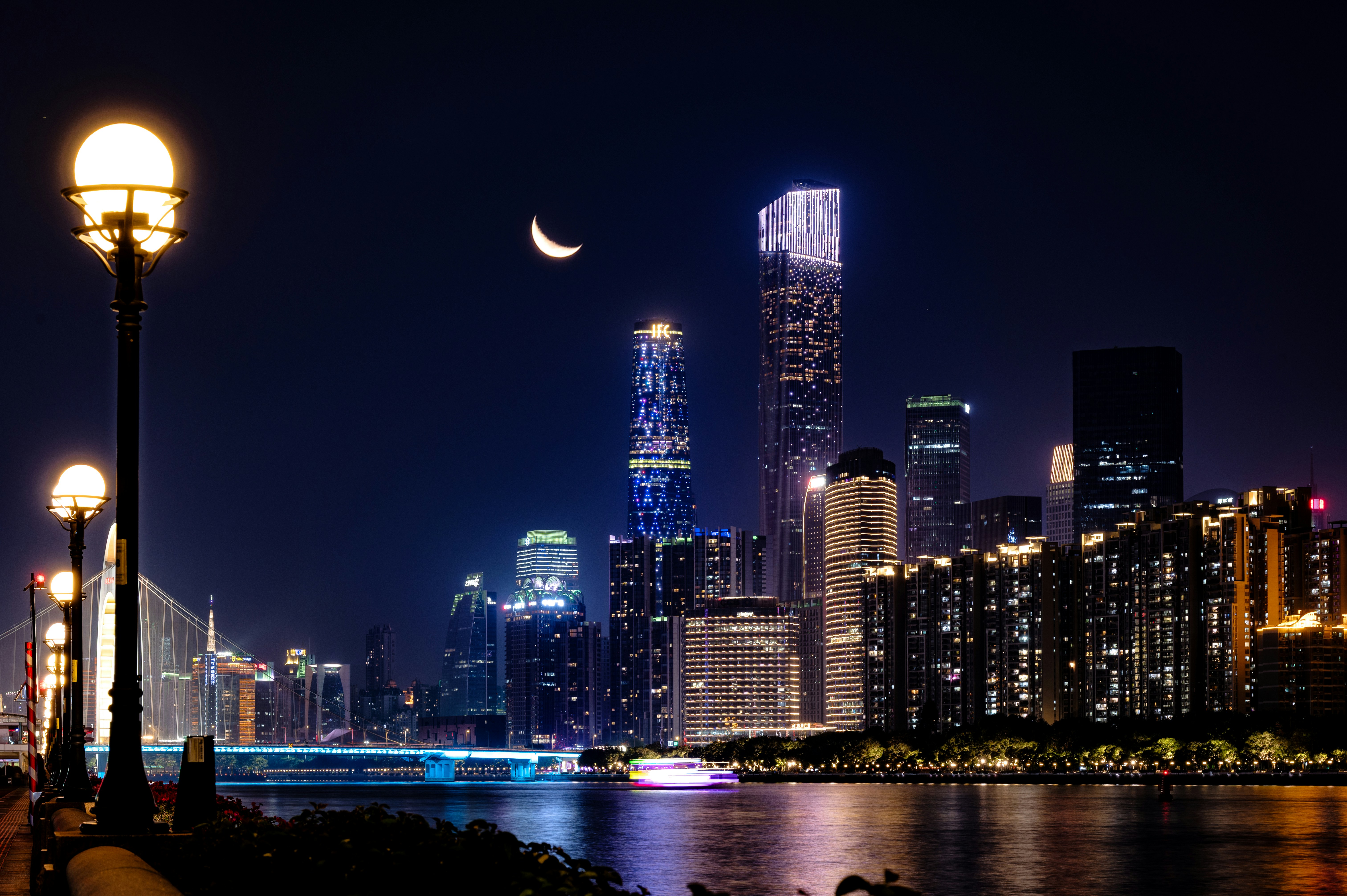 City skyline at night with crescent moon