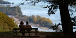 Couple sitting on bench overlooking autumn landscape