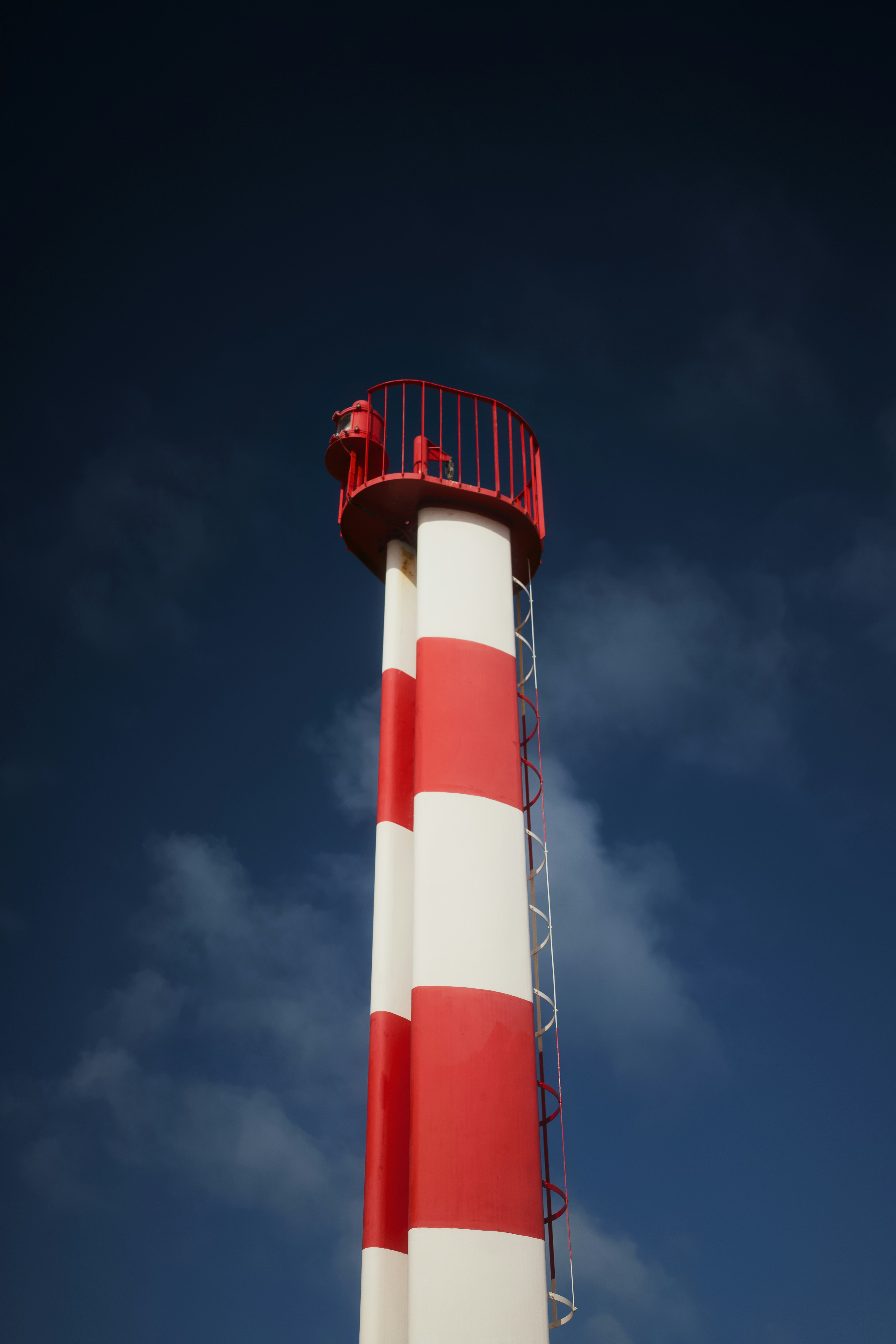 Tall red and white striped tower against dark sky
