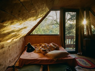 Cozy bedroom with a large window and sunlight