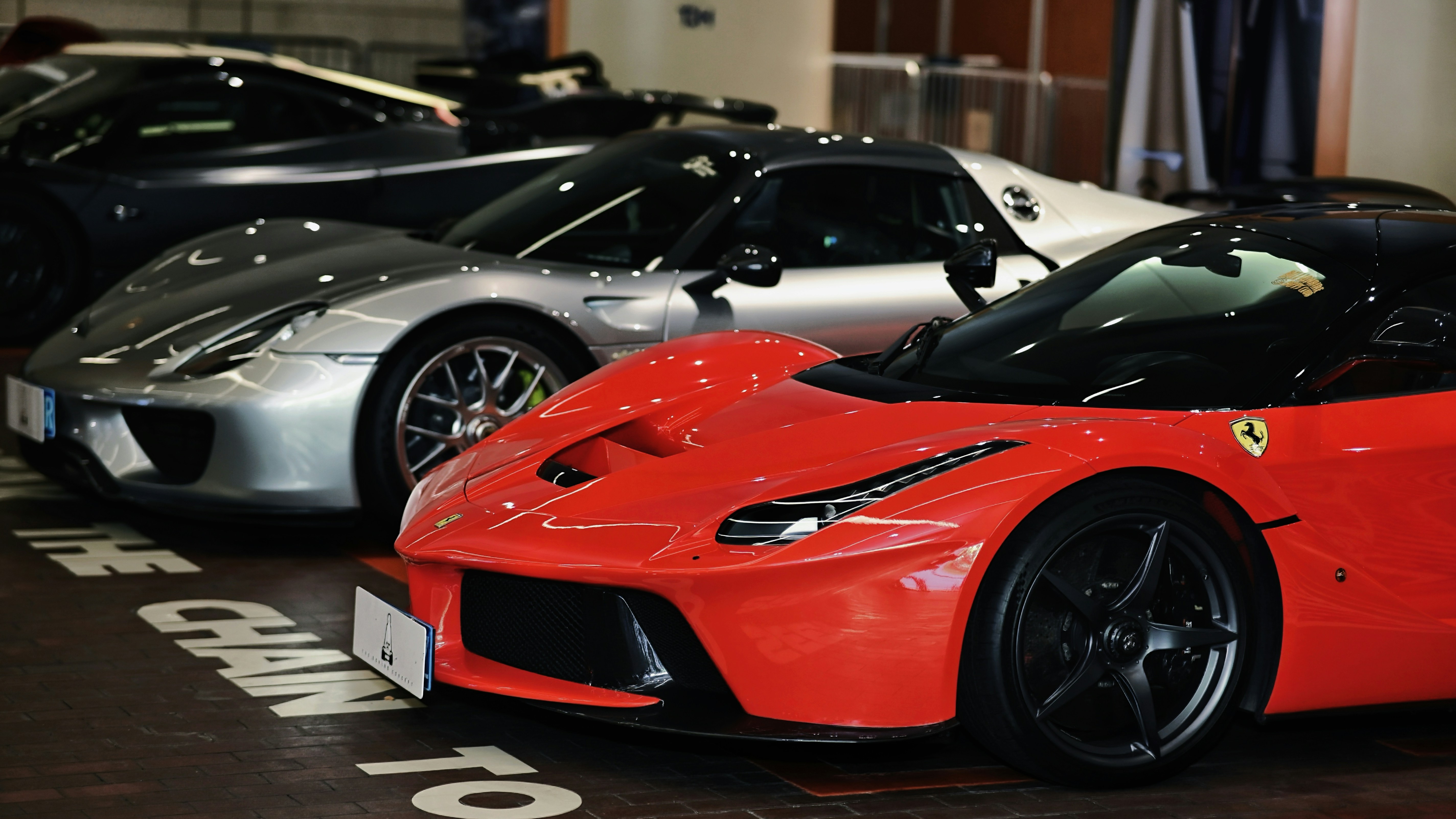 Several luxury sports cars parked in a row.