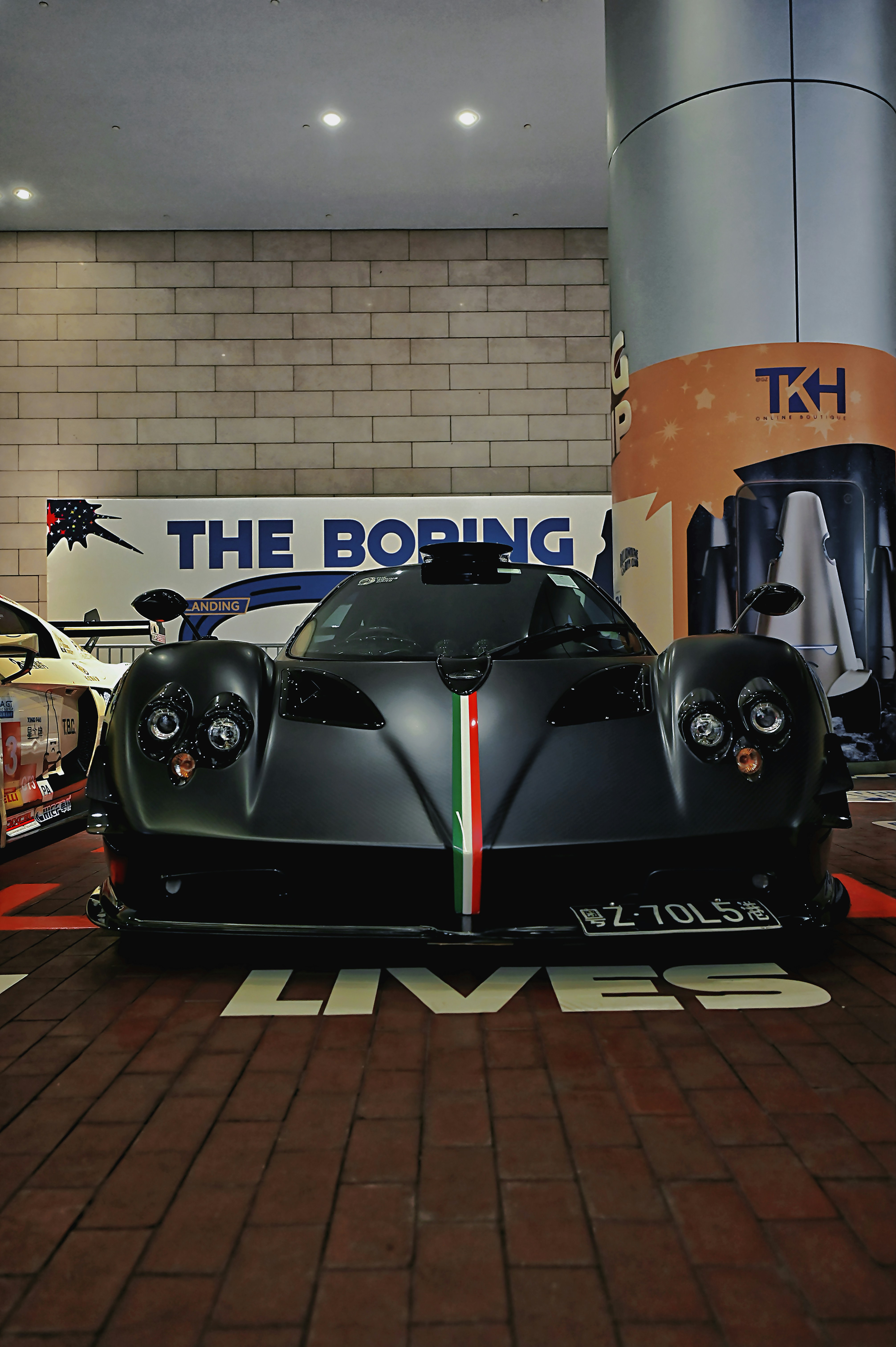 A black sports car with italian flag stripe on front.