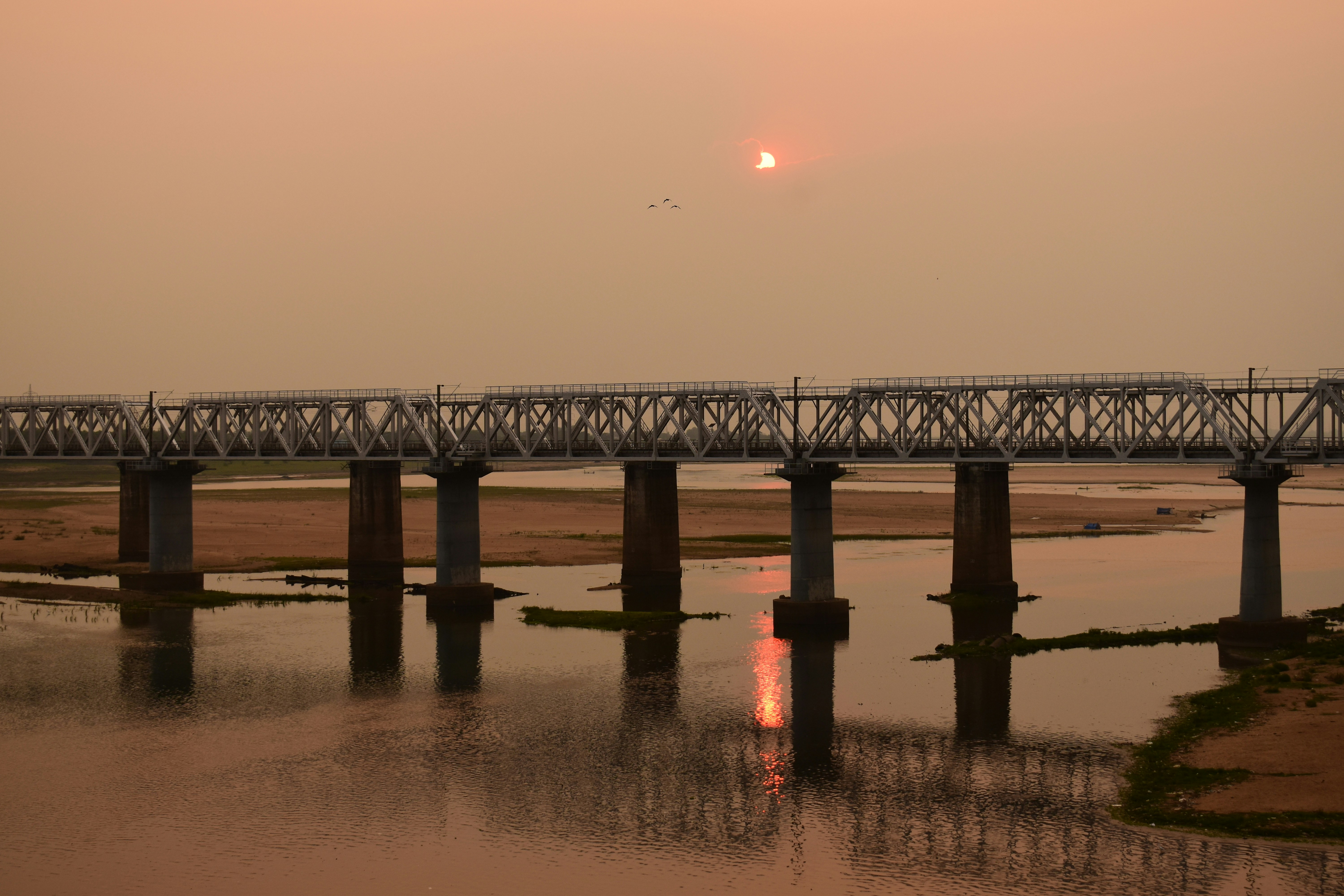 Train crossing a bridge at sunset