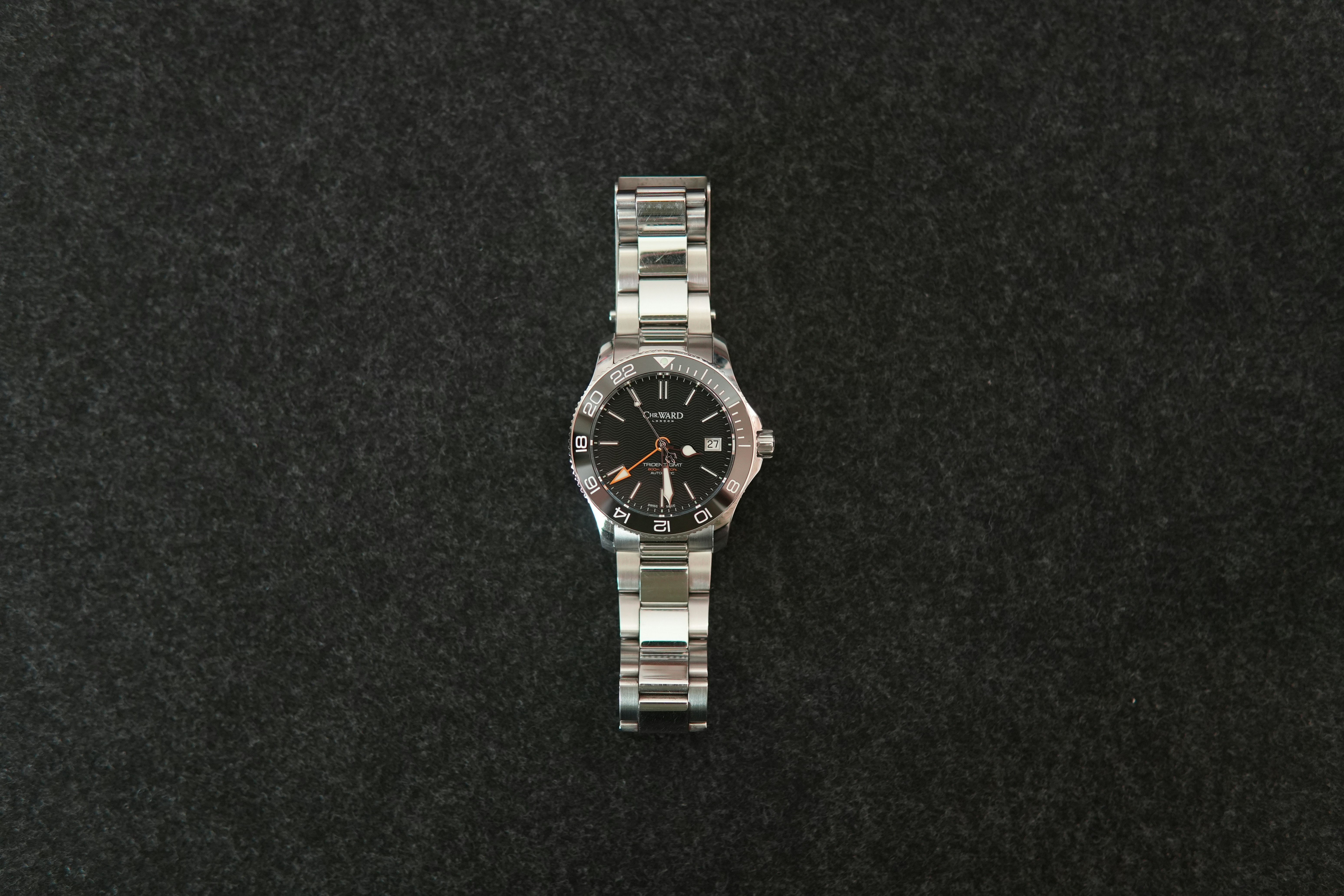 A silver wristwatch on a dark background