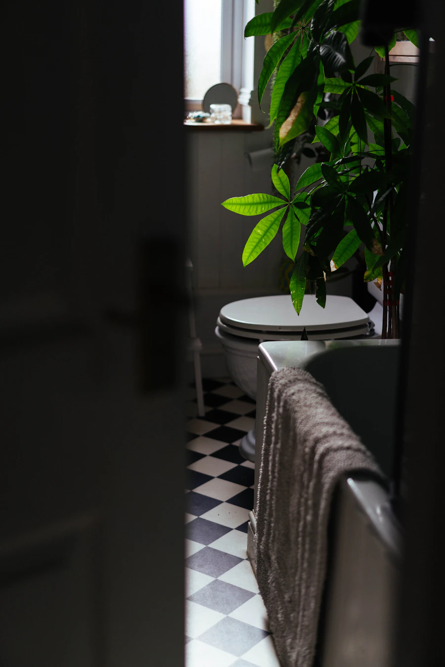 Bathroom with a chequered porcelain tile floor and a freestanding bathtub