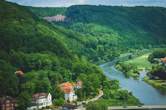 River winding through a lush green valley with houses.