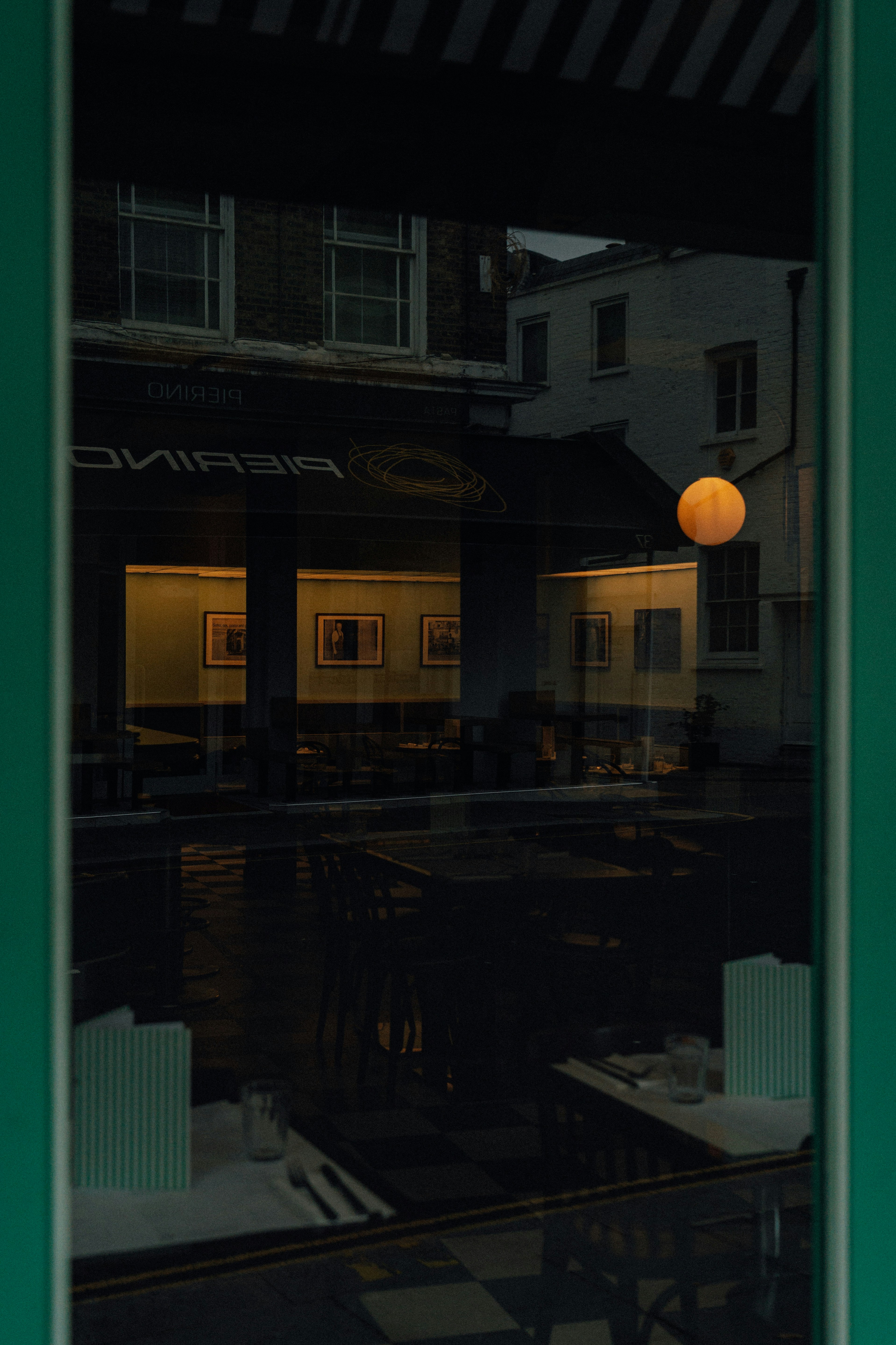 Reflection of a cafe interior with orange light.