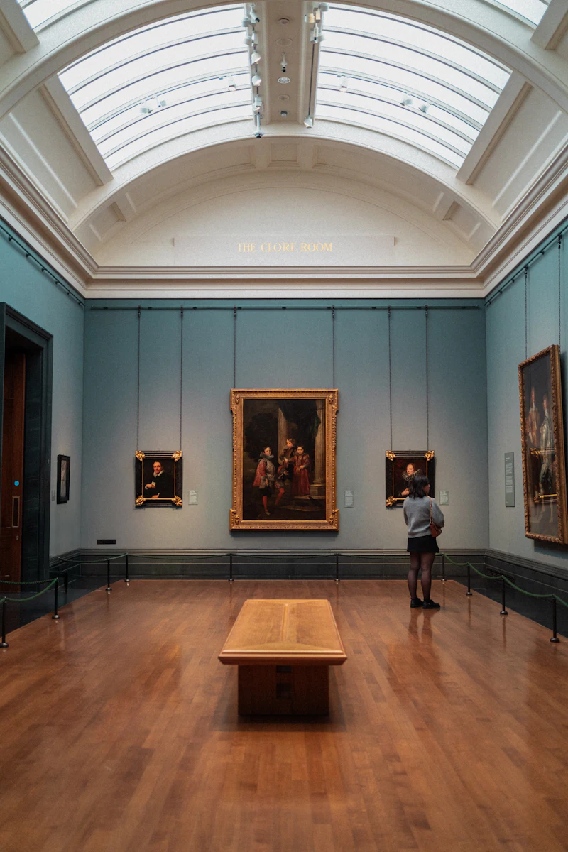 A visitor studying paintings in a gallery
