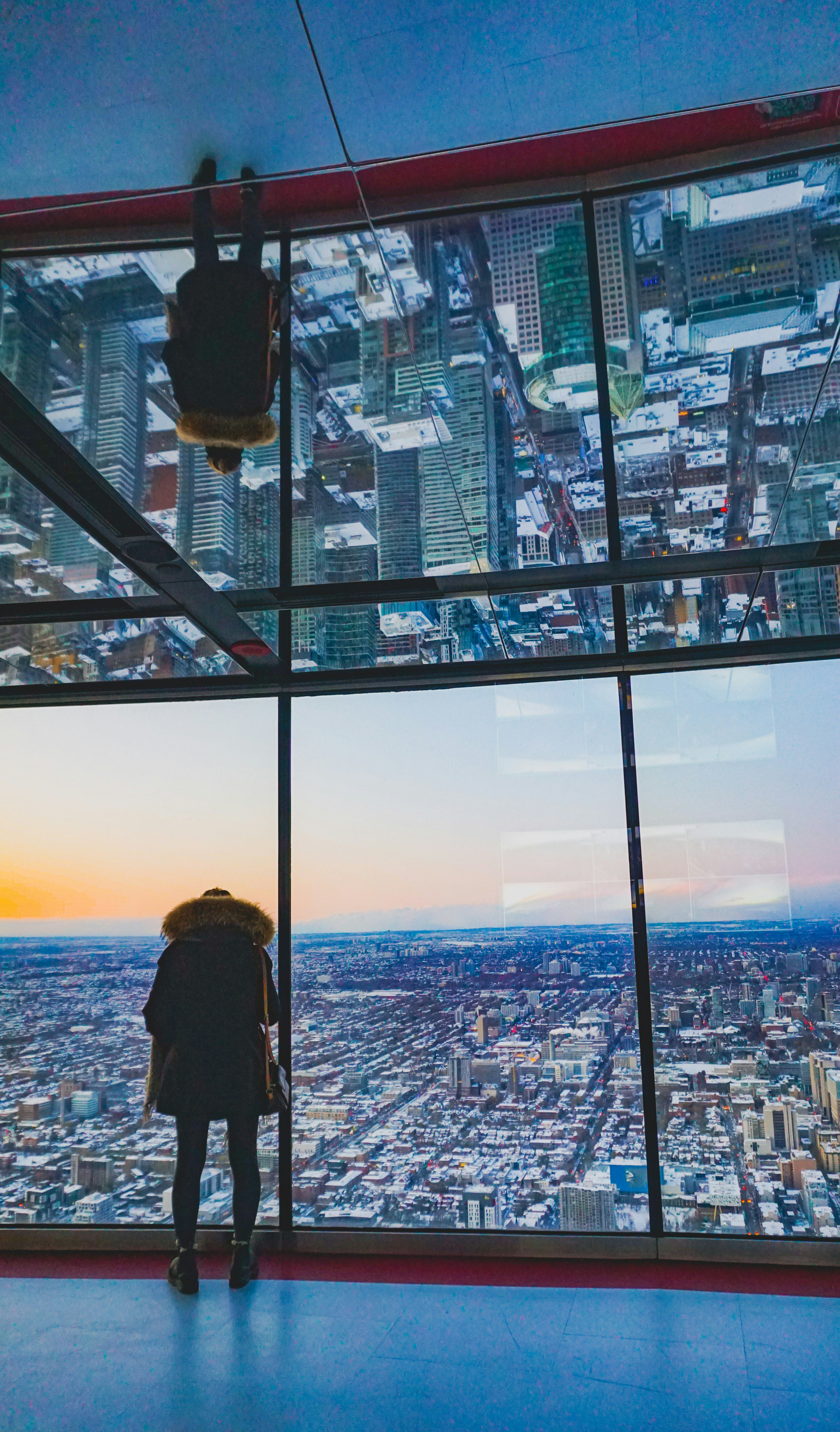 Woman looking at snowy cityscape from above.