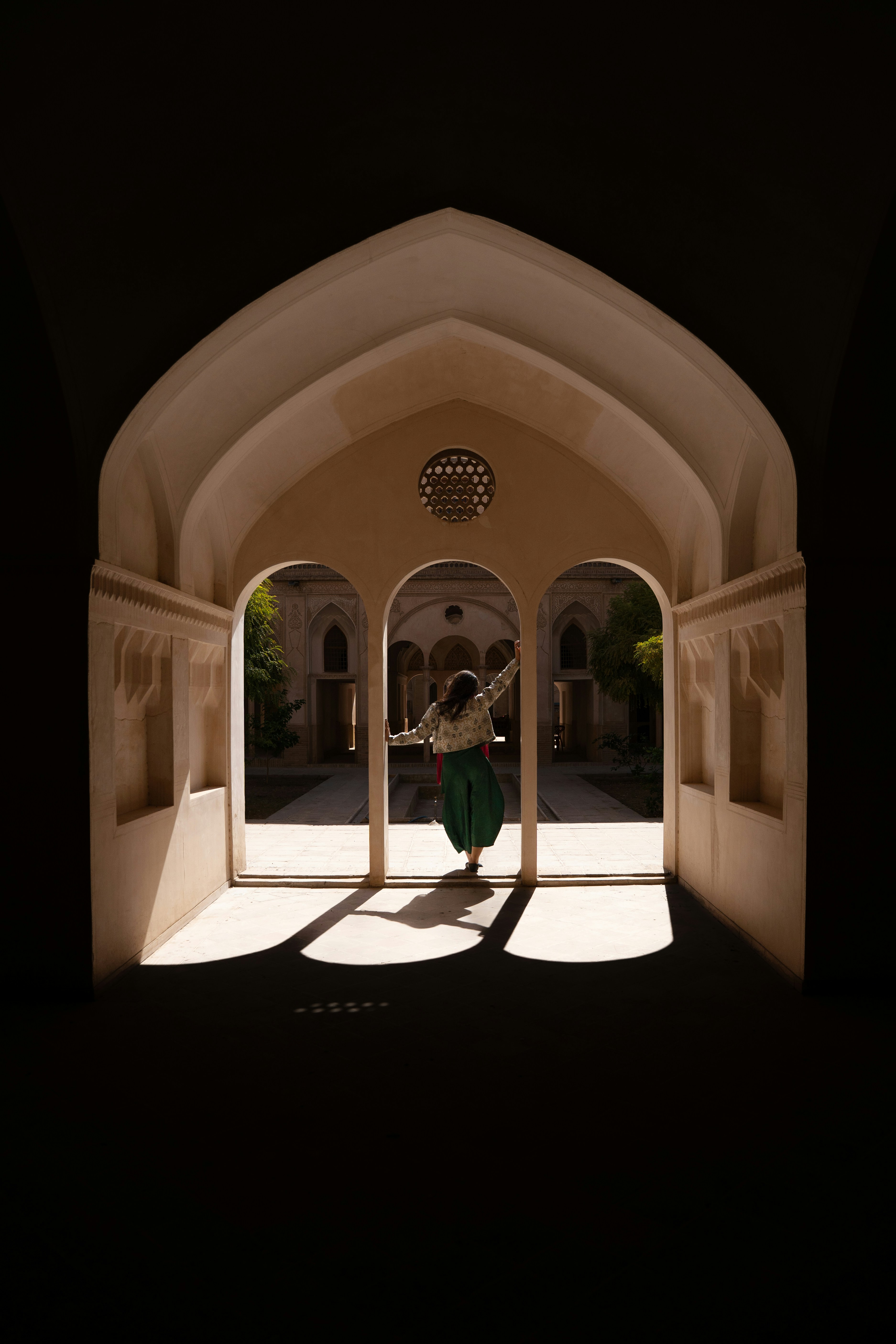 Woman dancing in archway of courtyard