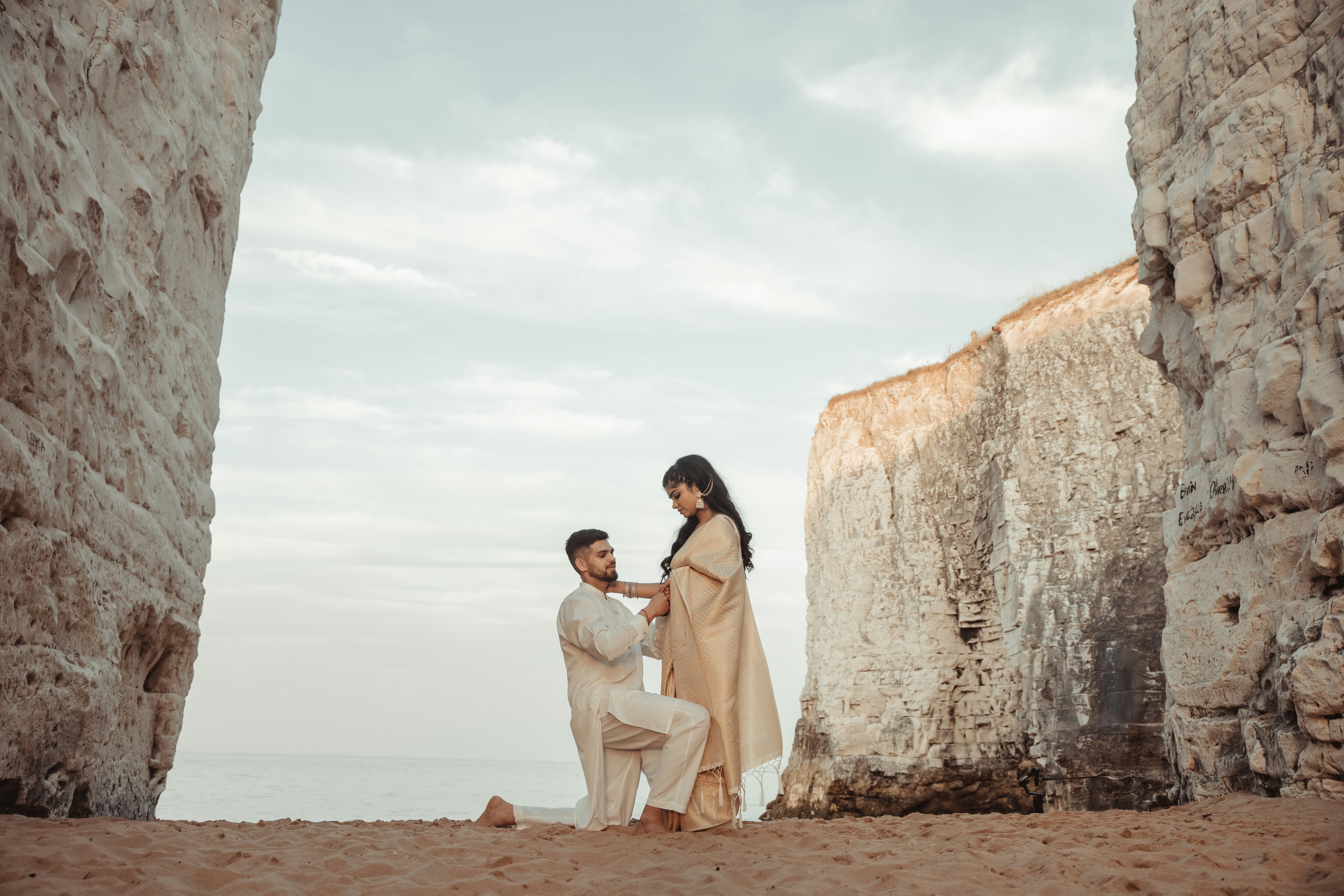 Man proposes to woman on a beach.