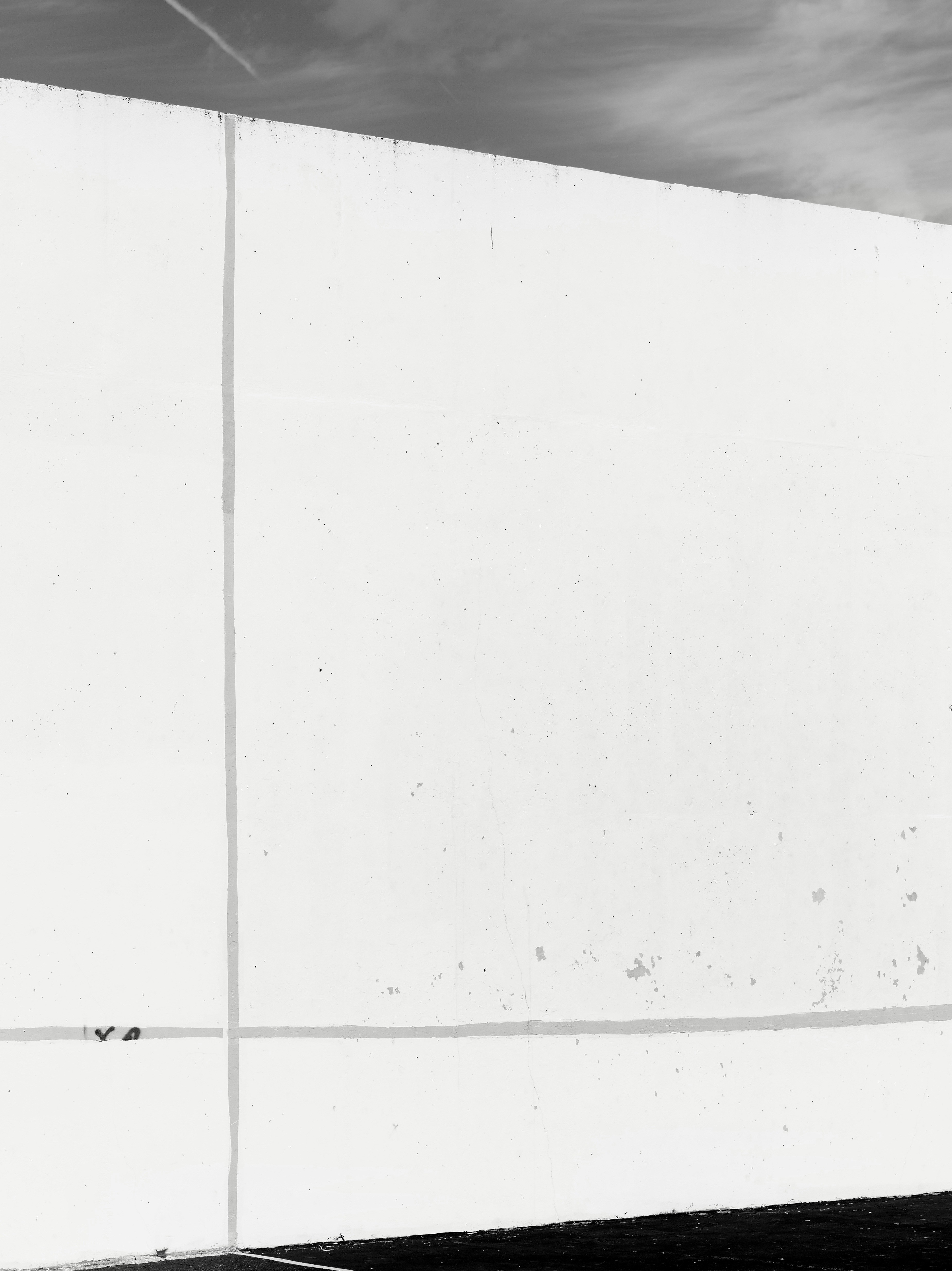 A white wall with one vertical and one horizontal line drawn on it