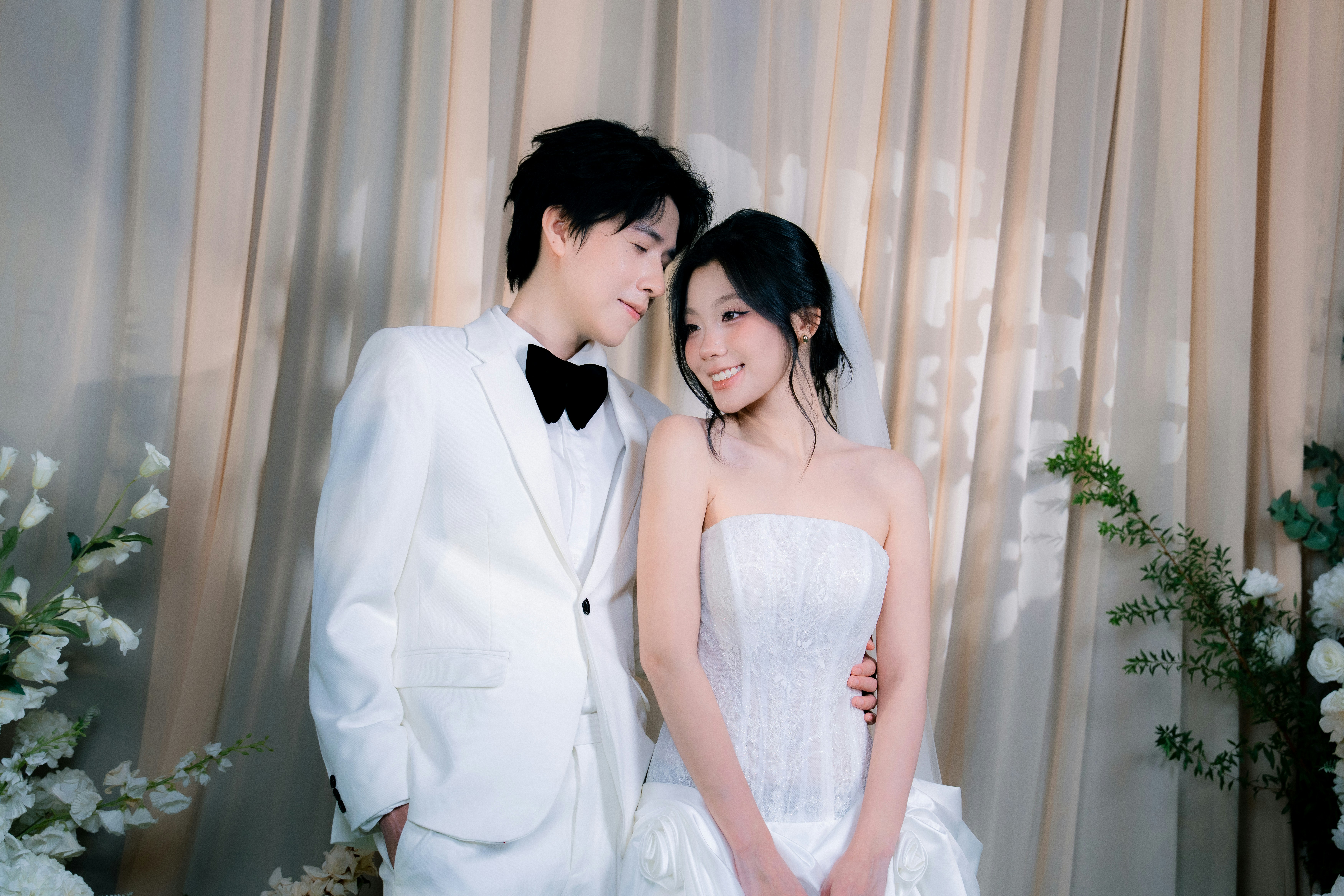 A bride and groom in wedding attire smiling