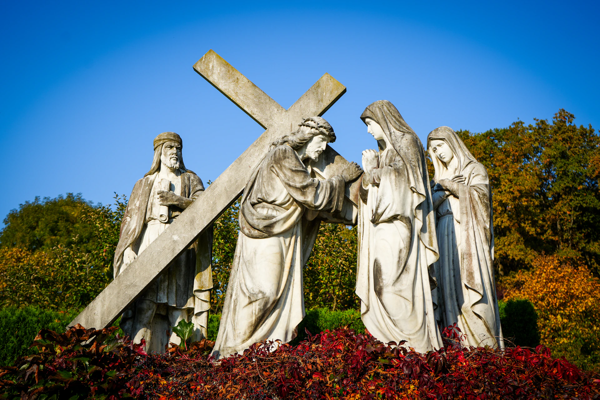 Statues depicting jesus carrying the cross with women