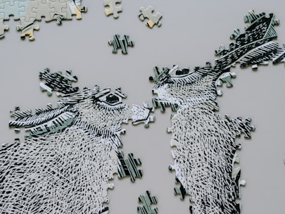 Two unfinished donkey puzzle pieces face each other.