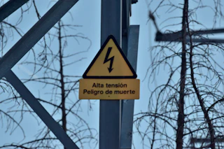 A green high-voltage warning sign that reads danger of death.