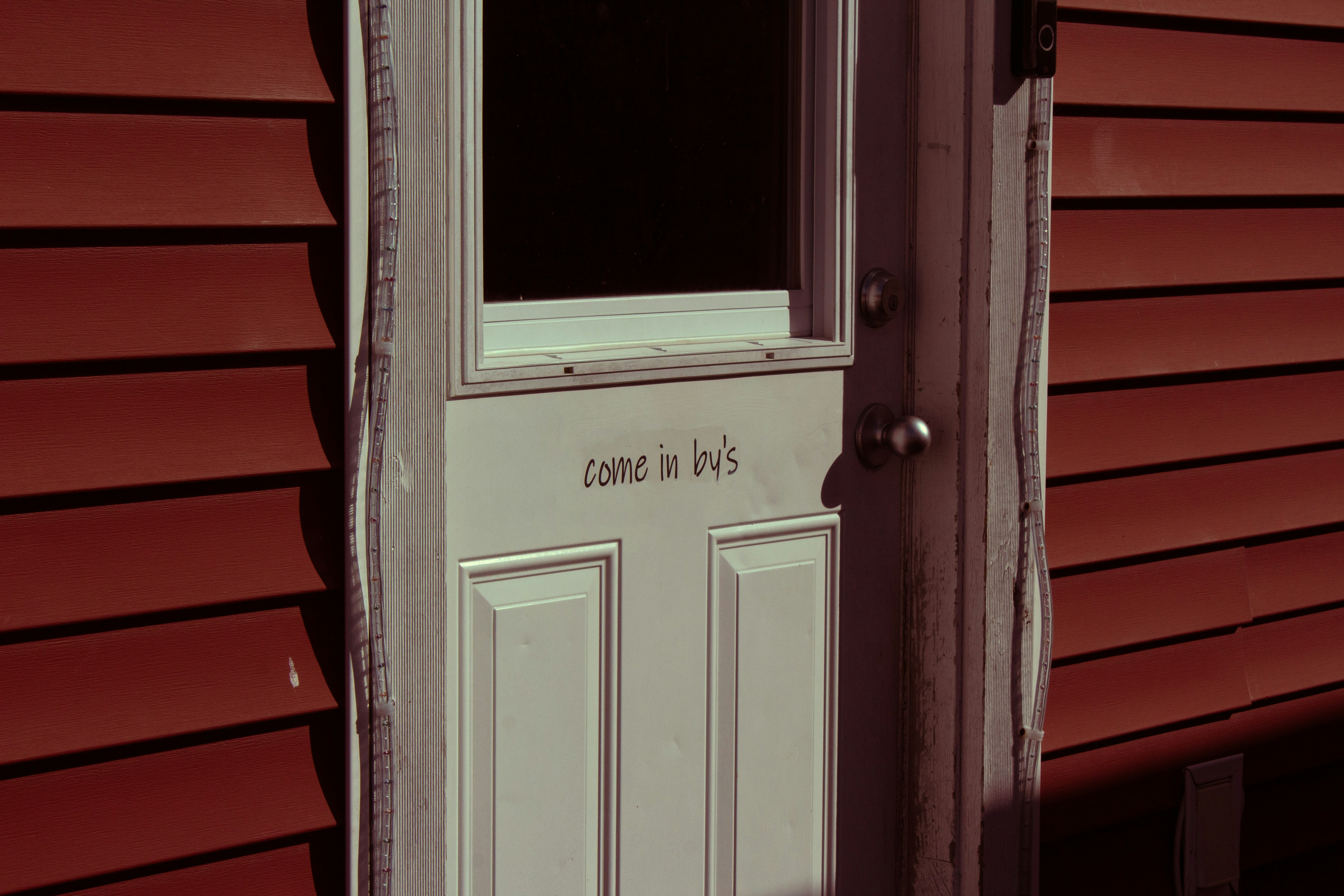A white door with text on a red wall.