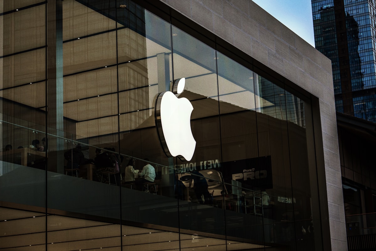 Apple store exterior with large illuminated logo on modern glass building