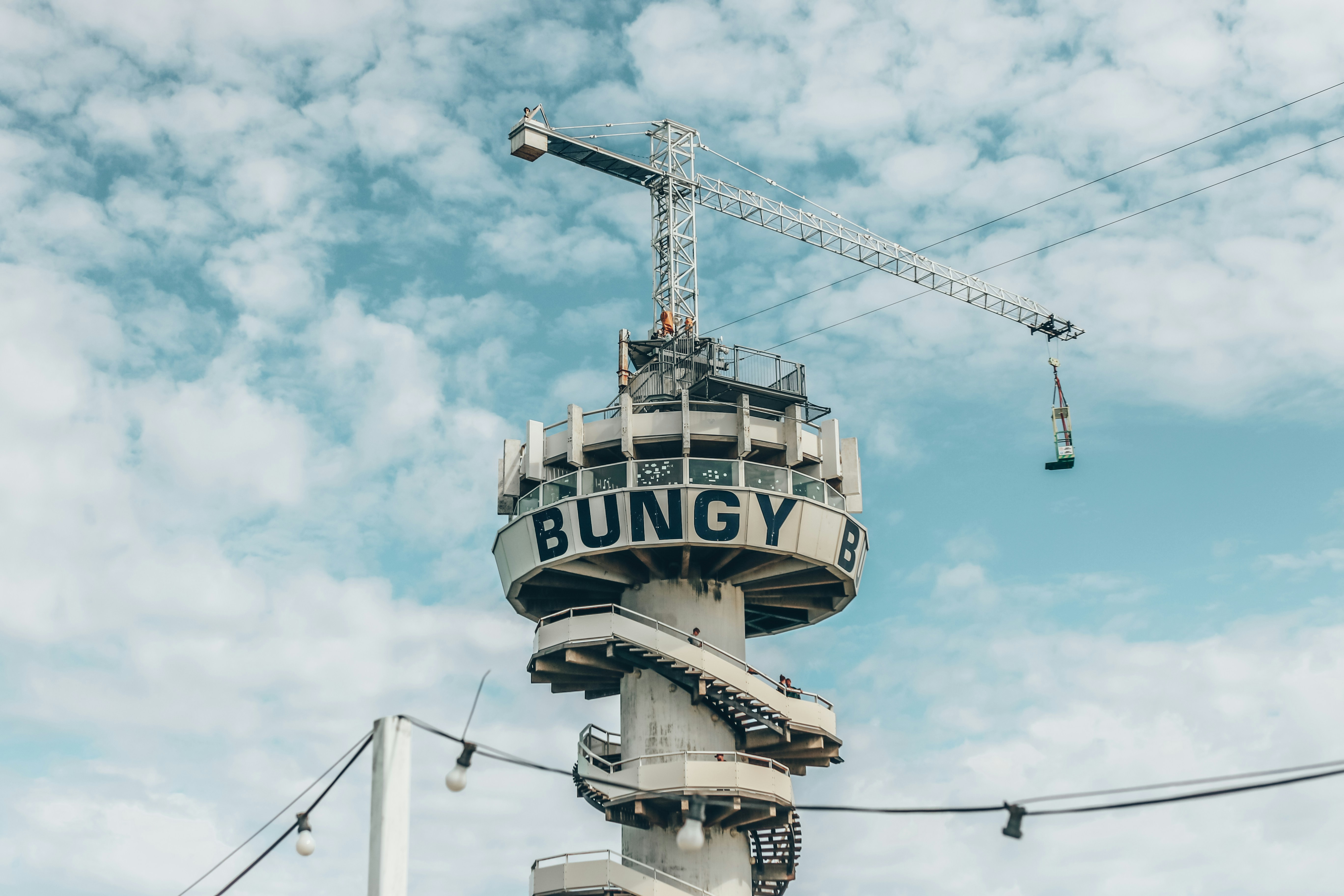 Bungy jump tower with crane against blue sky
