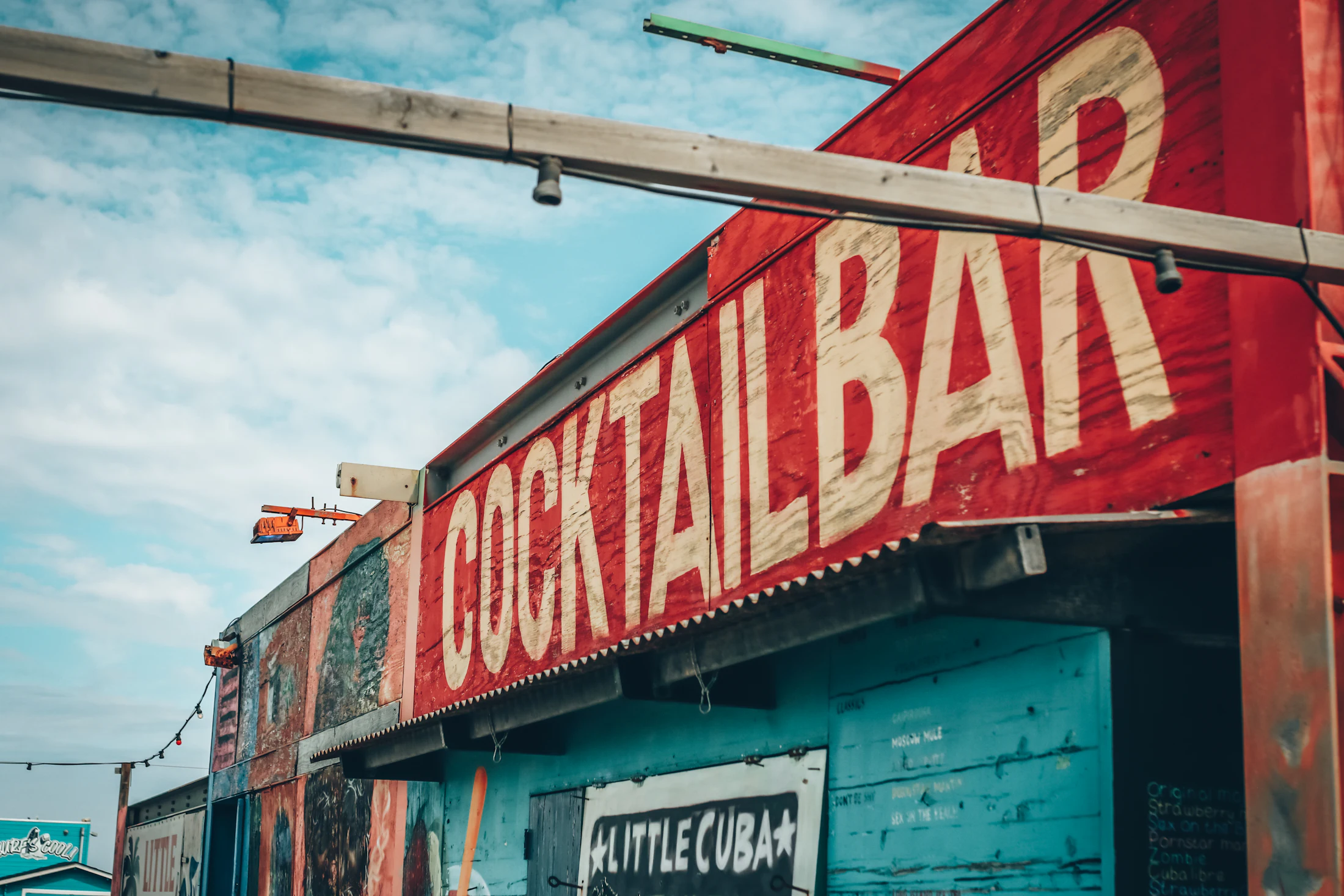 Gevel van een kleurrijke cocktailbar met de tekst Little Cuba