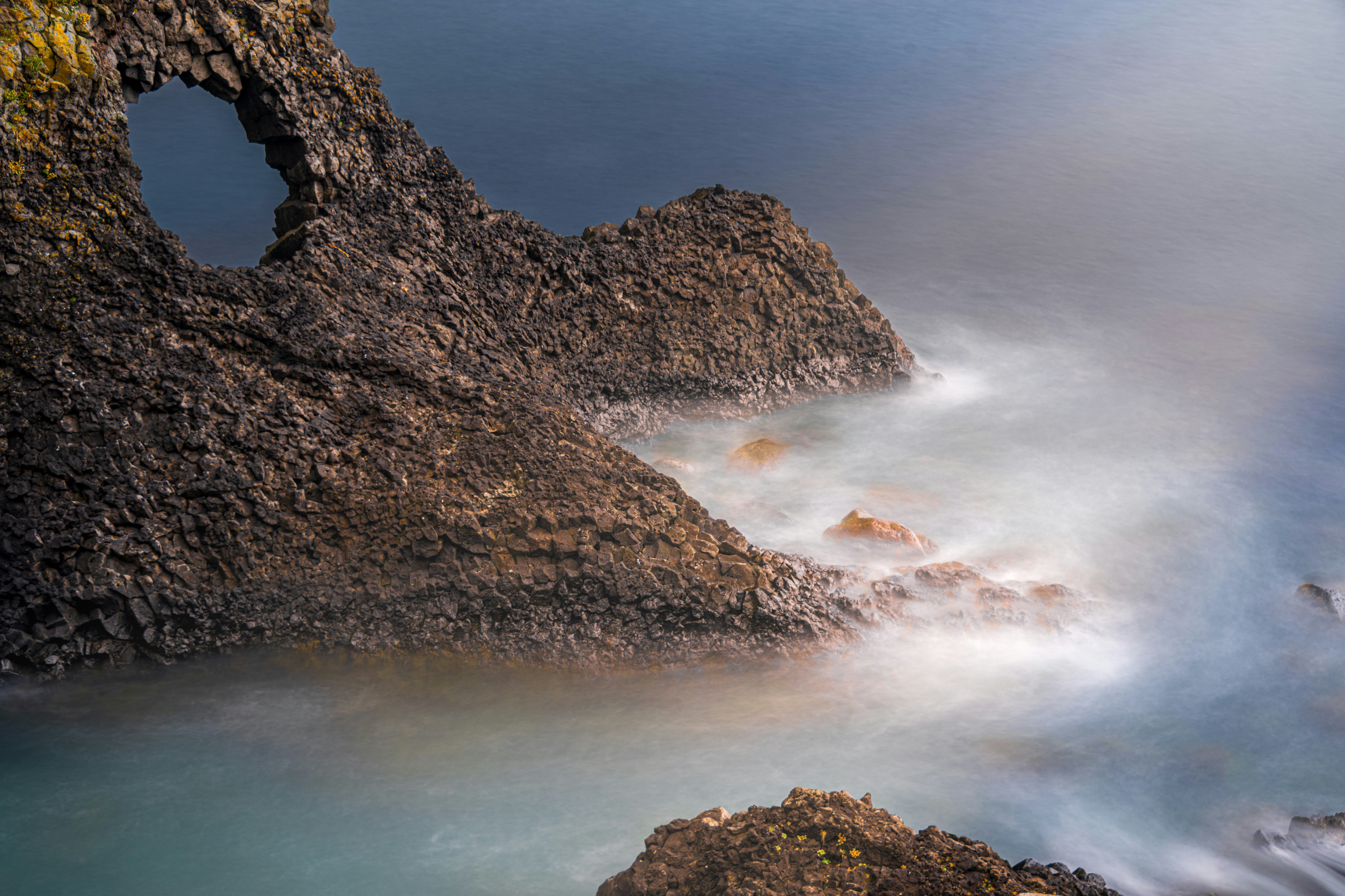 Rocky coastline with a natural arch and ocean waves